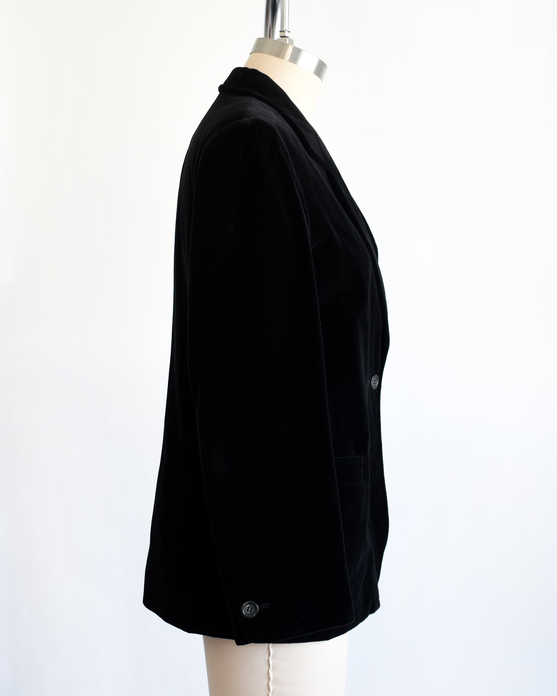 side view of a vintage black blazer on a mannequin against a white background