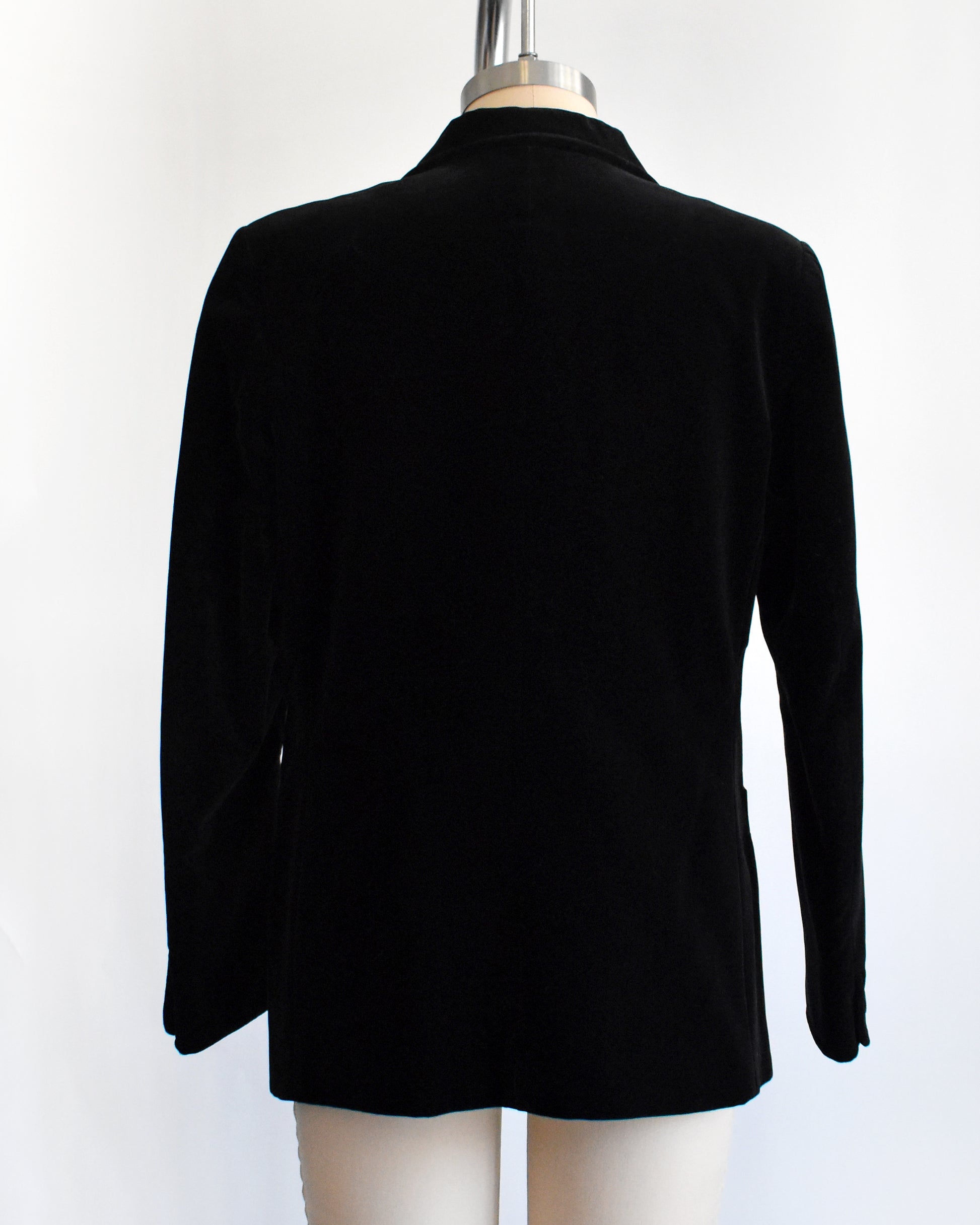 back view of a vintage black blazer on a mannequin against a white background