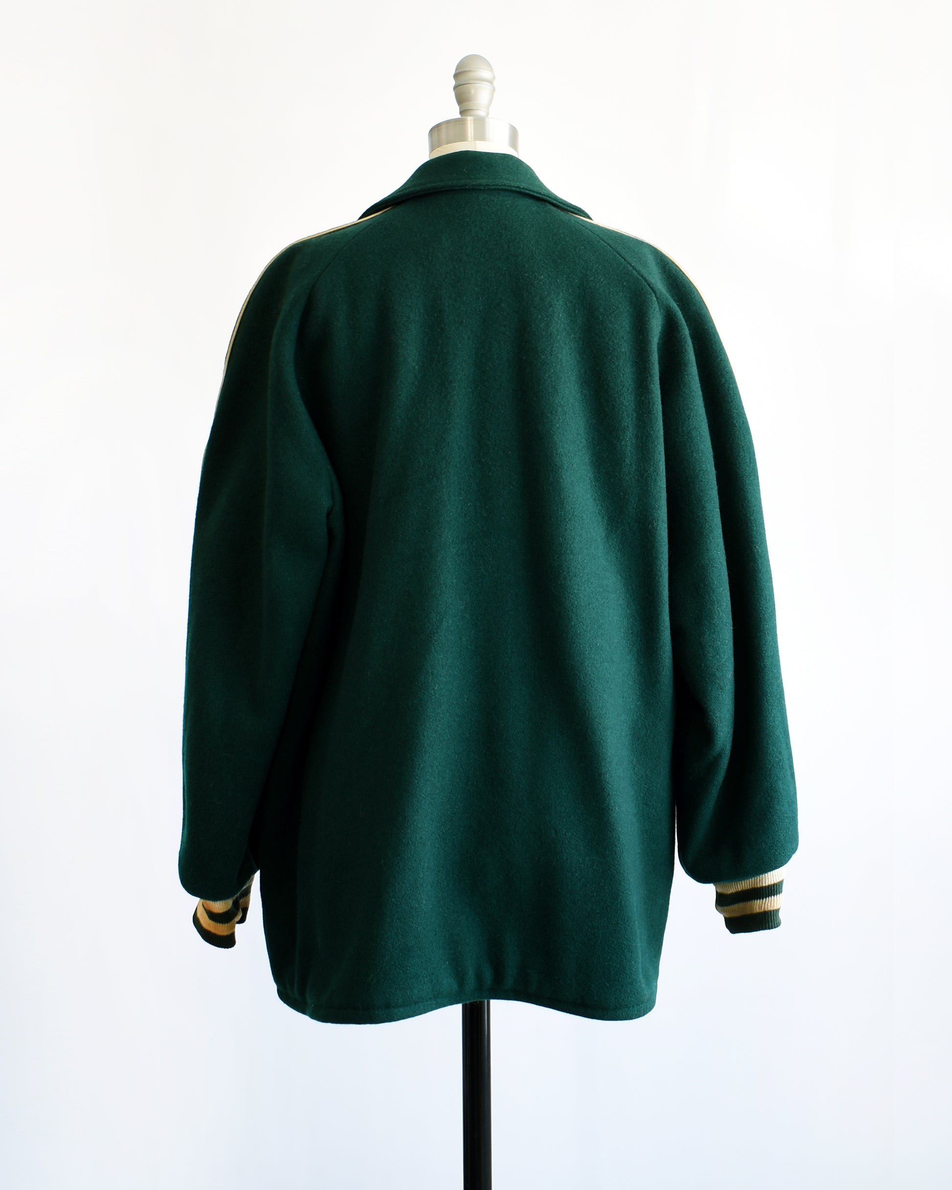 back view of a vintage 1950s green varsity jacket with white text on a mannequin against a white background