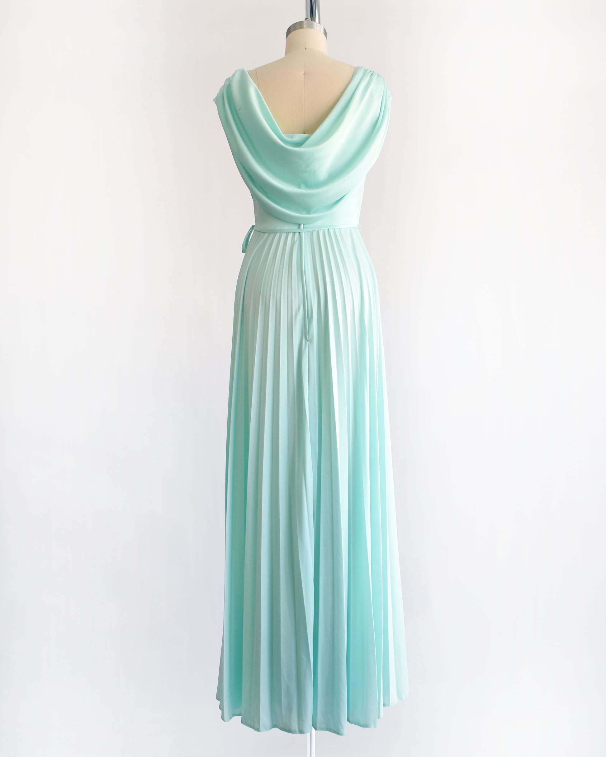 back view of a vintage 1970s seafoam dress on a mannequin against a white background