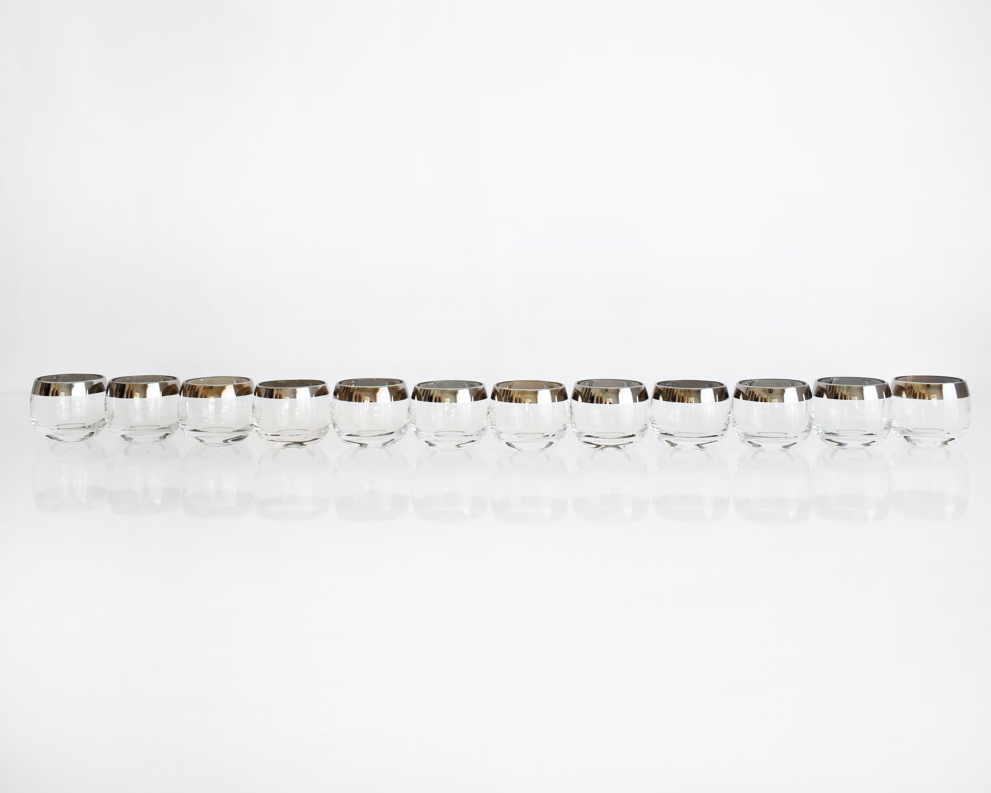 a row of twelve silver rim roly poly glasses