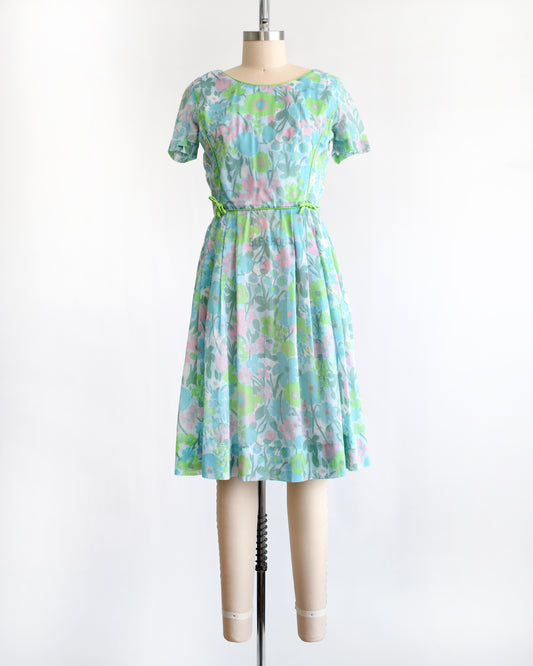 a vintage 1960s floral dress on a mannequin against a white background