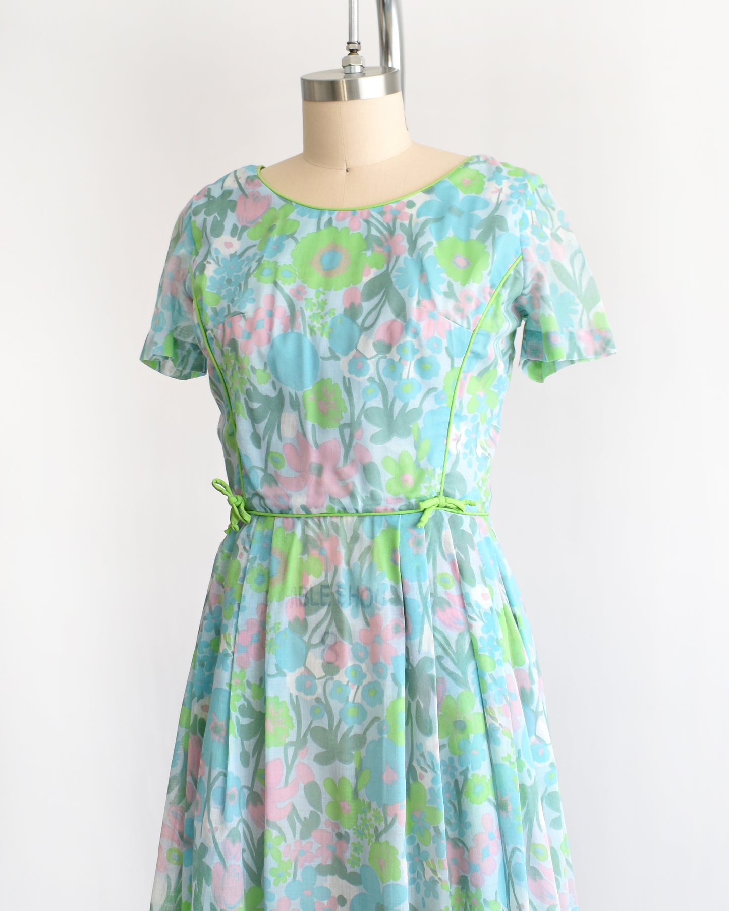 side font view of a vintage 1960s floral dress on a mannequin against a white background