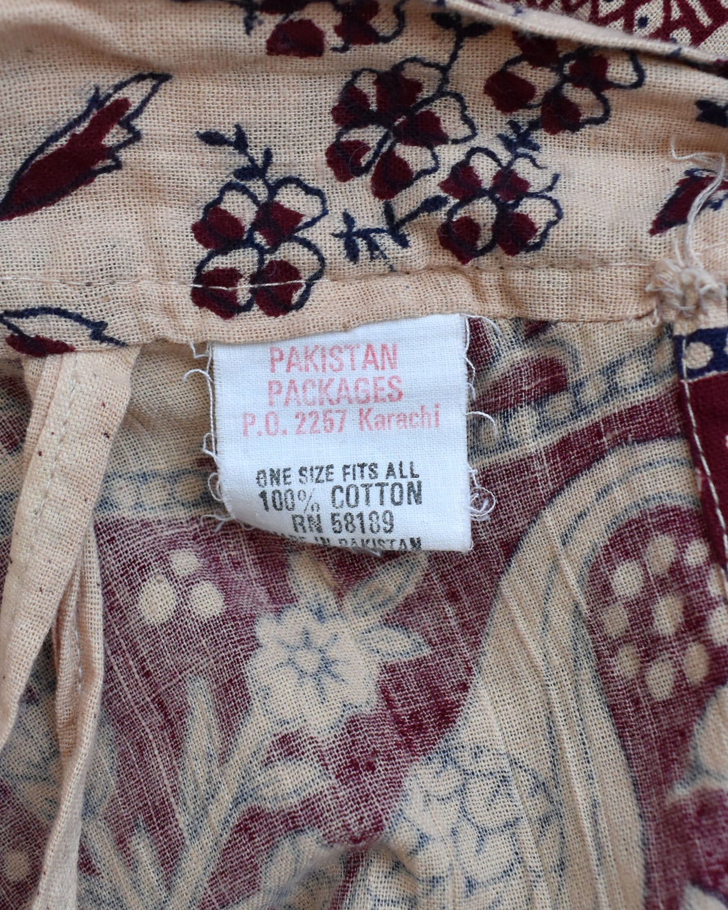 Textile with a visible label reading 'Pakistan Packages' on a patterned fabric background.