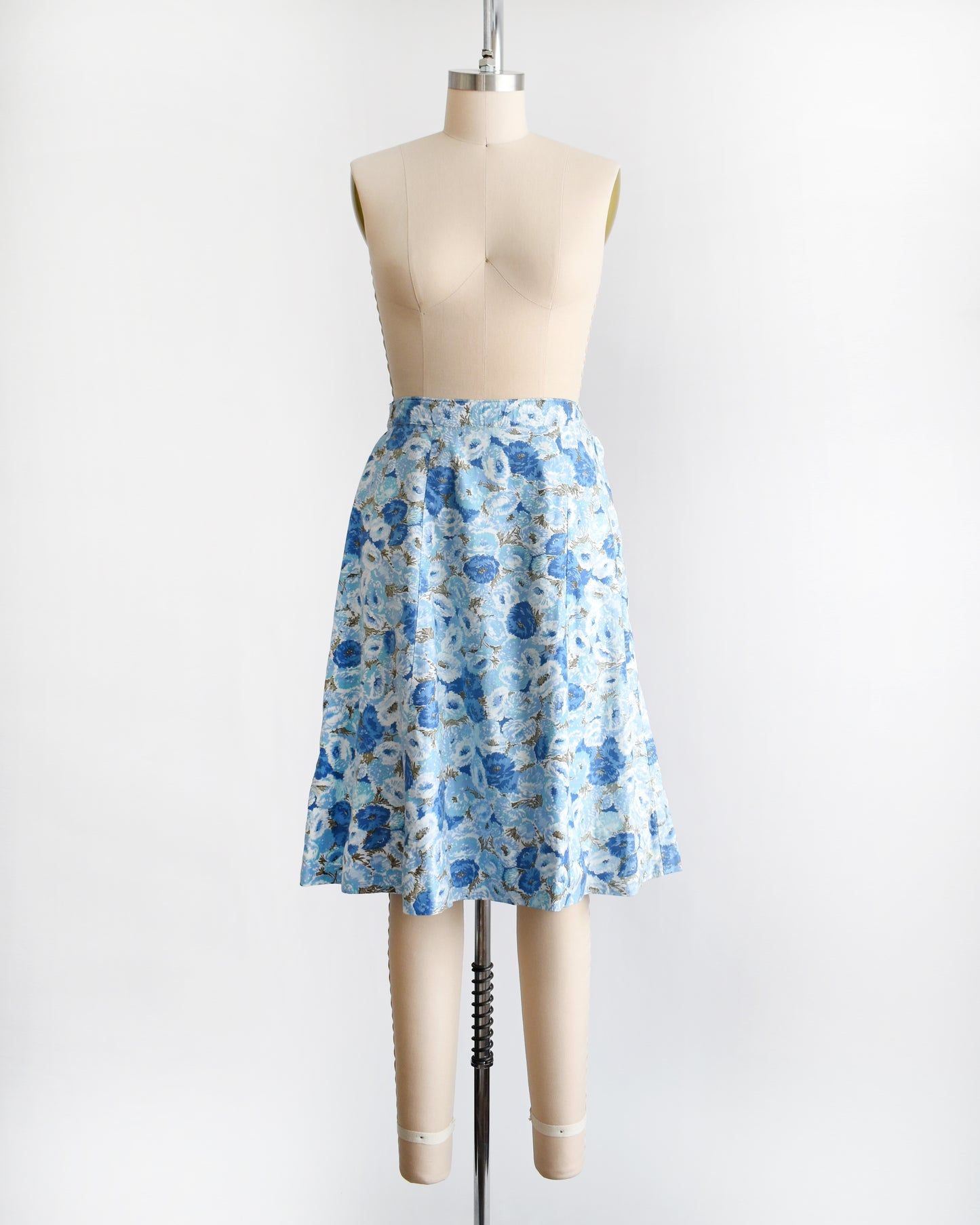 a vintage blue floral skirt on a mannequin against a white background