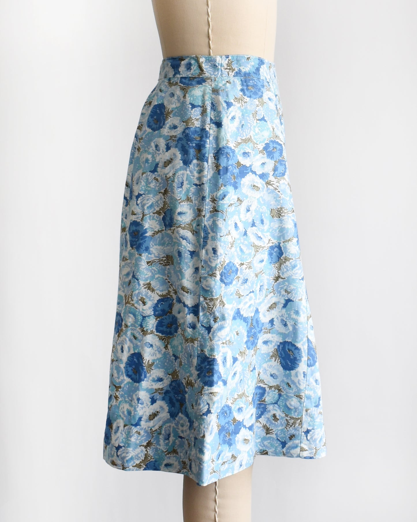 side view of a vintage blue floral skirt on a mannequin against a white background