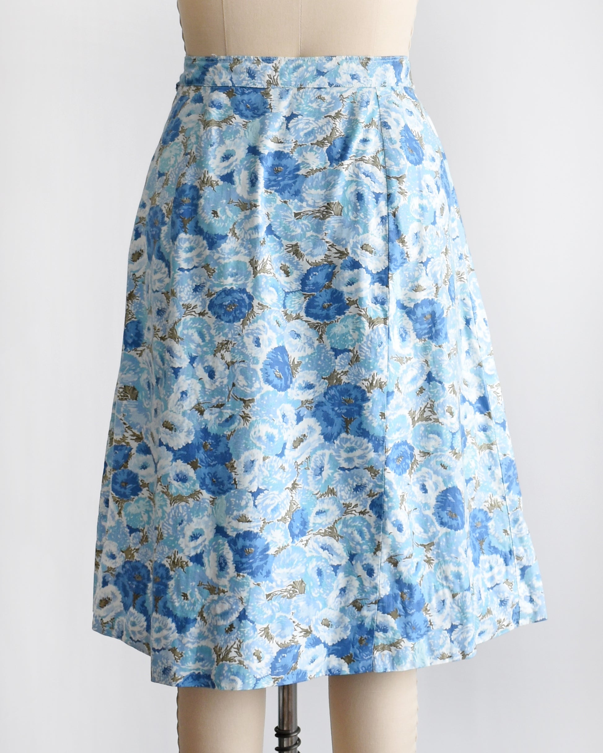 back view of a vintage blue floral skirt on a mannequin against a white background