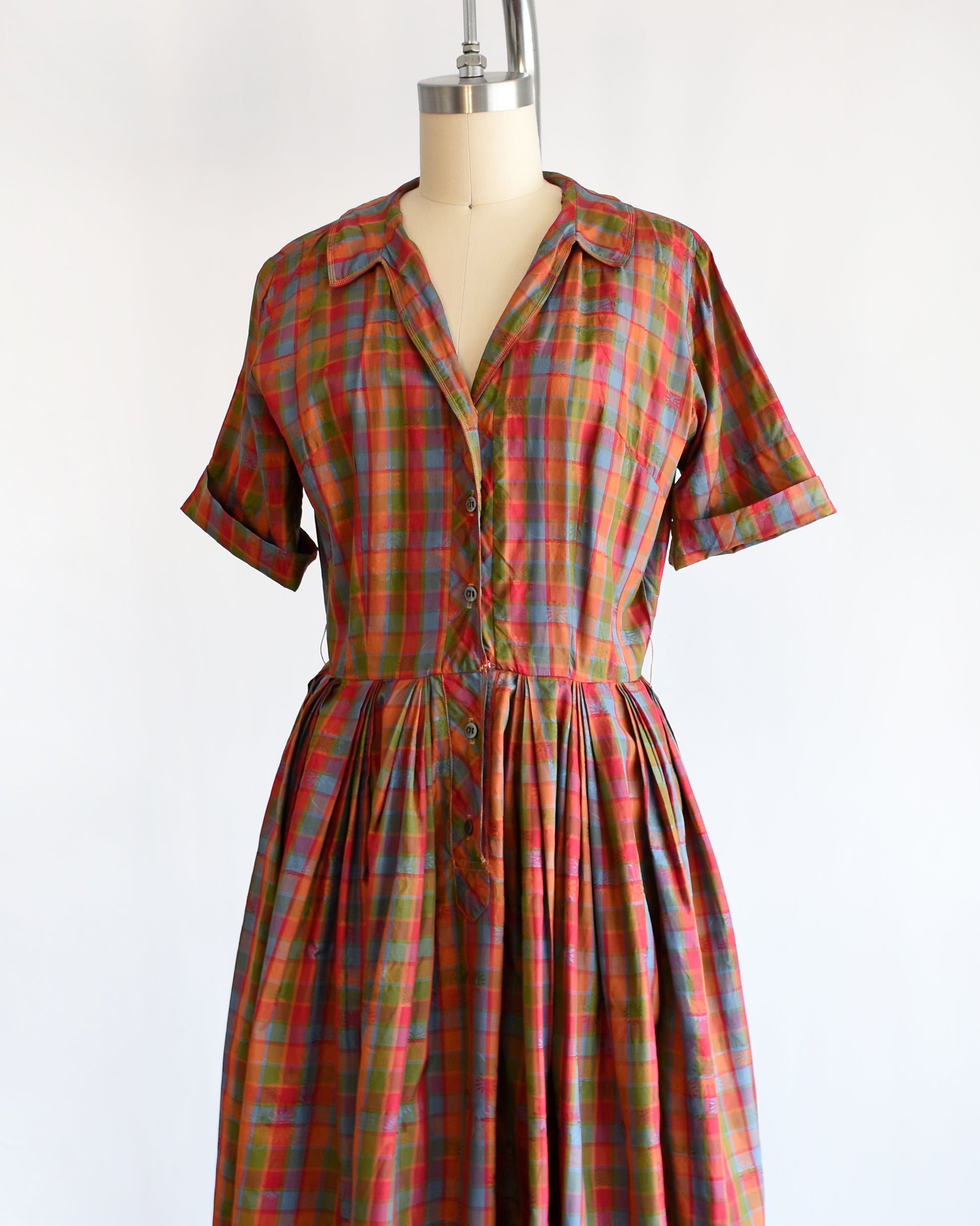 side front view of a vintage 1950s/1960s rainbow plaid silk dress on a mannequin on a white background