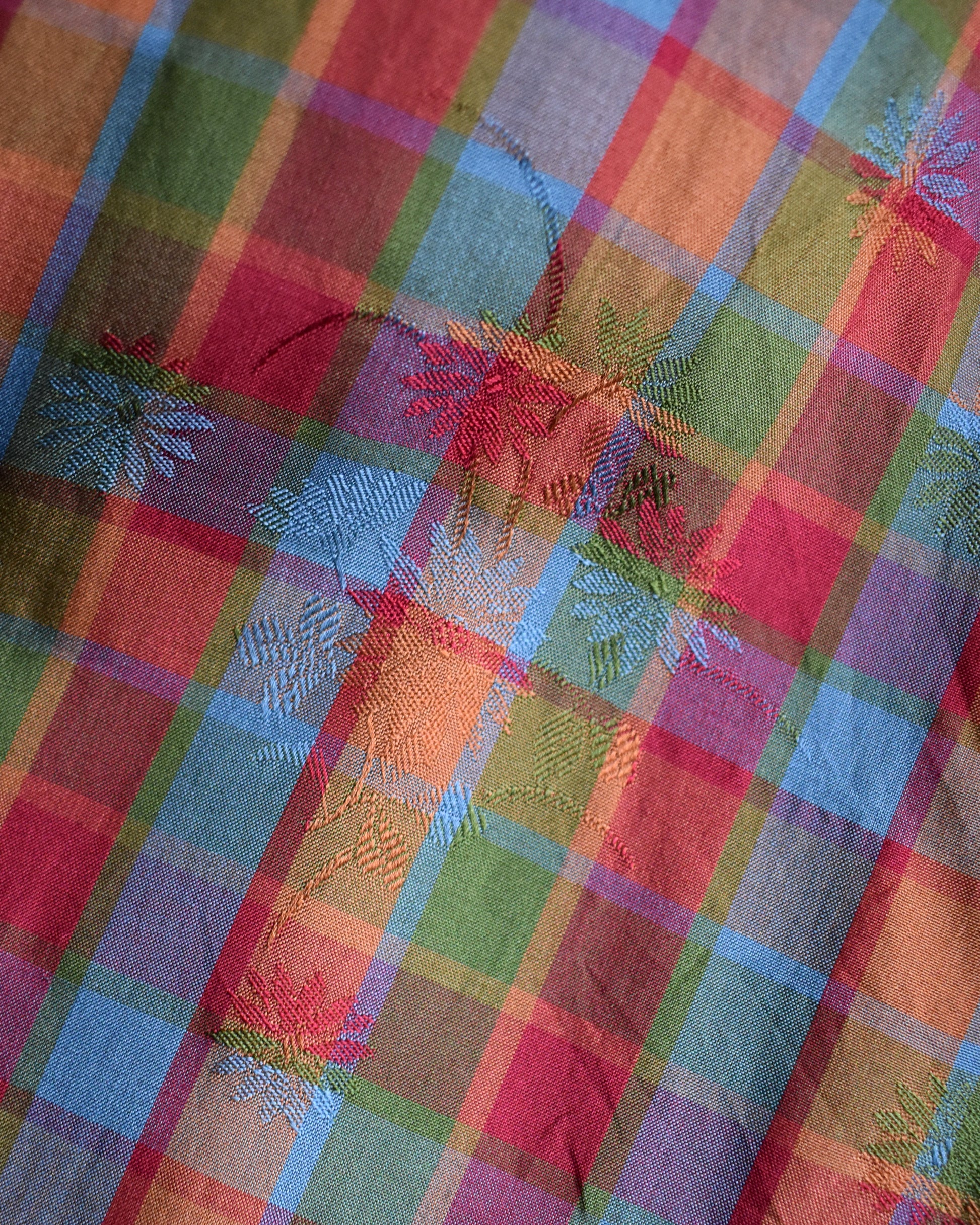 Close-up of a colorful plaid fabric with floral brocade