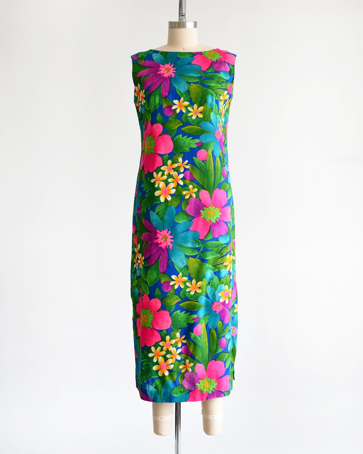 a vintage 1960s colorful floral dress on a mannequin against a white background