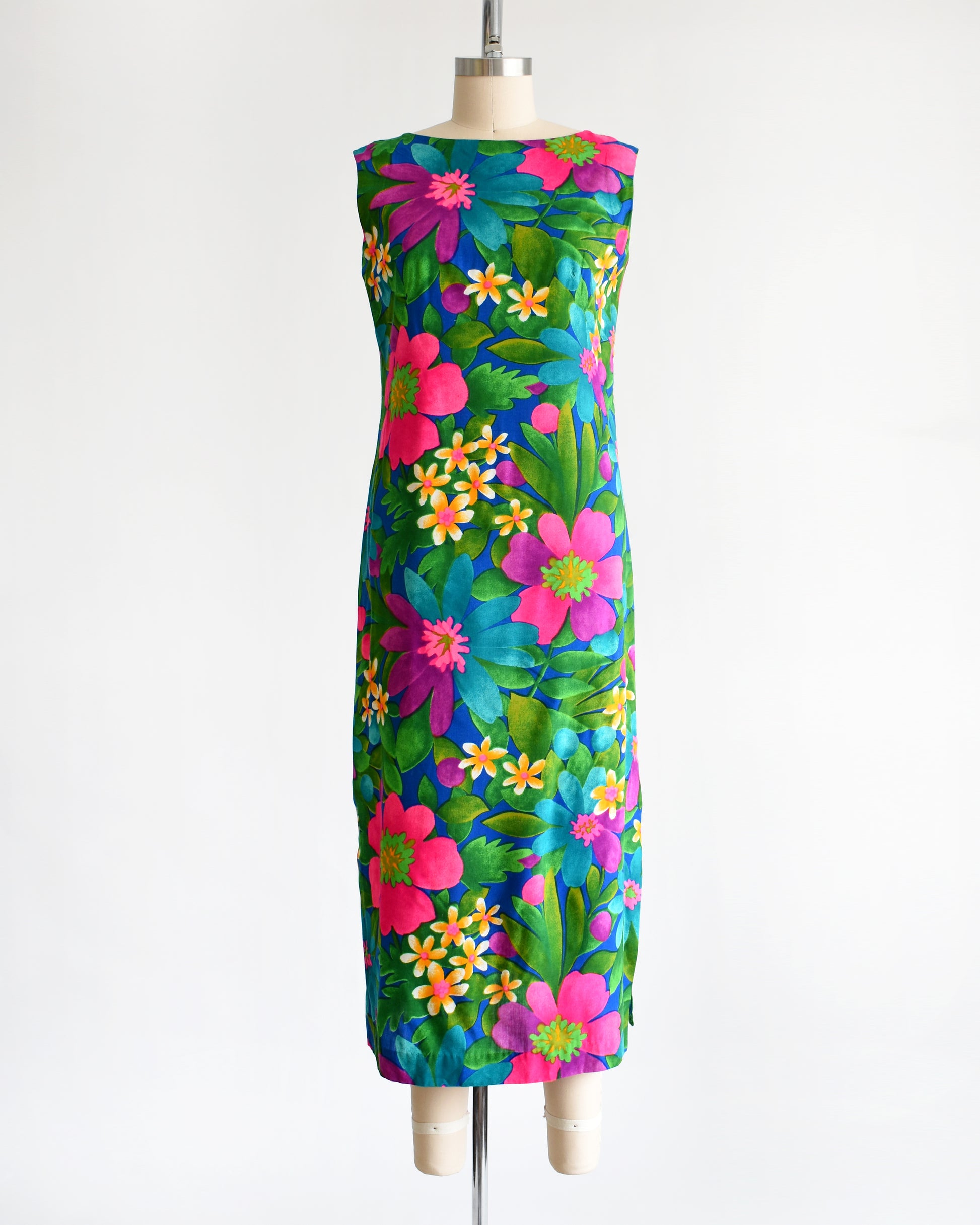 a vintage 1960s colorful floral dress on a mannequin against a white background