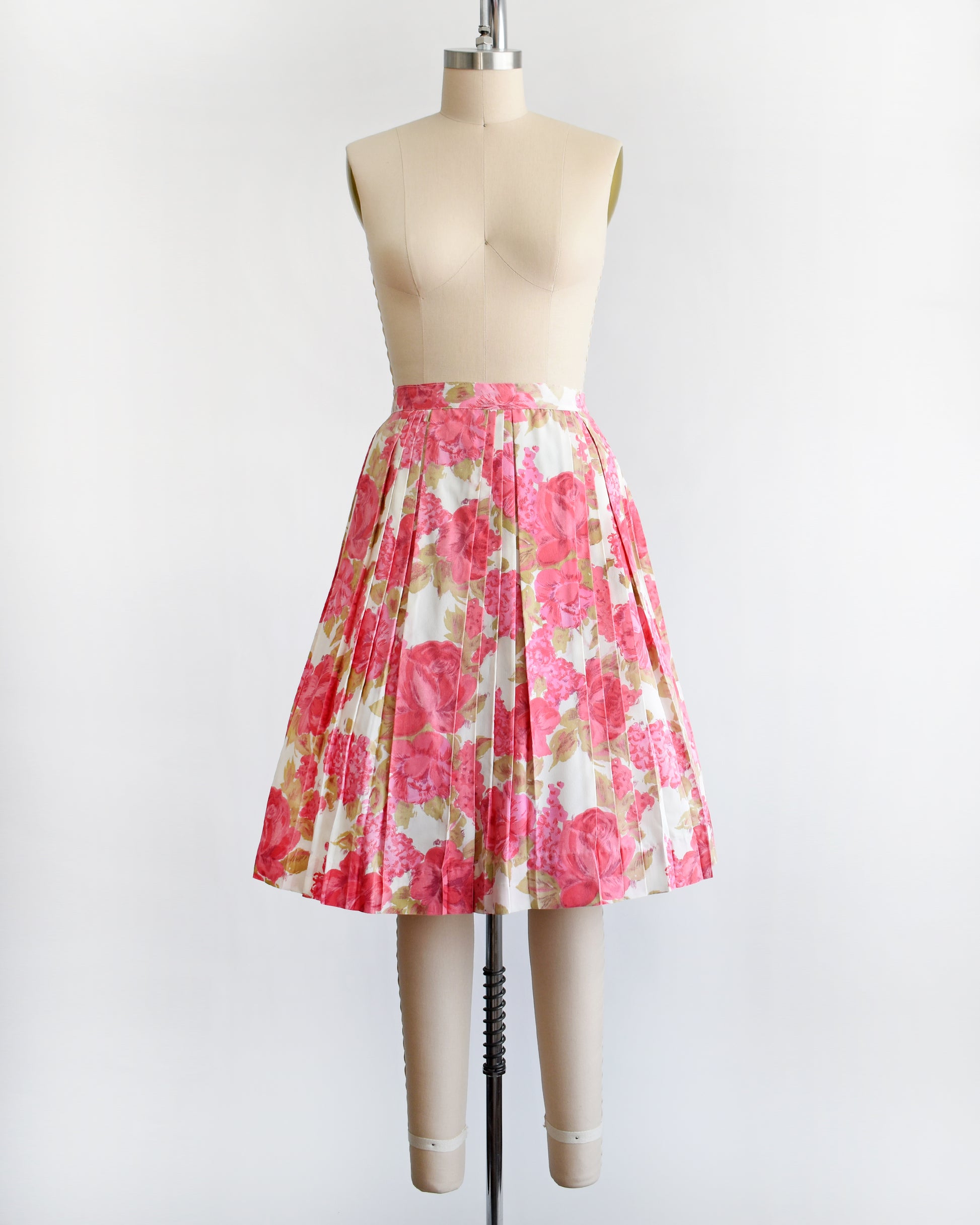 a vintage 1950s pink floral skirt on a mannequin against a white background