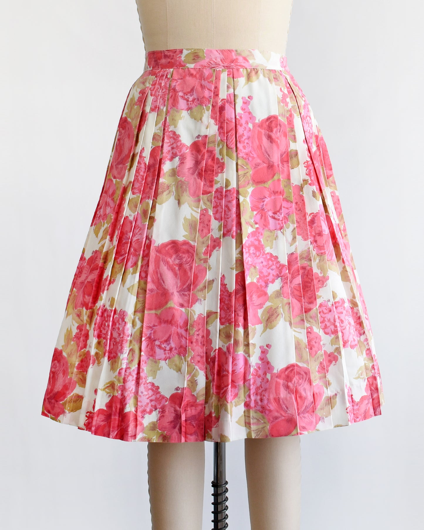 a vintage 1950s pink floral skirt on a mannequin against a white background