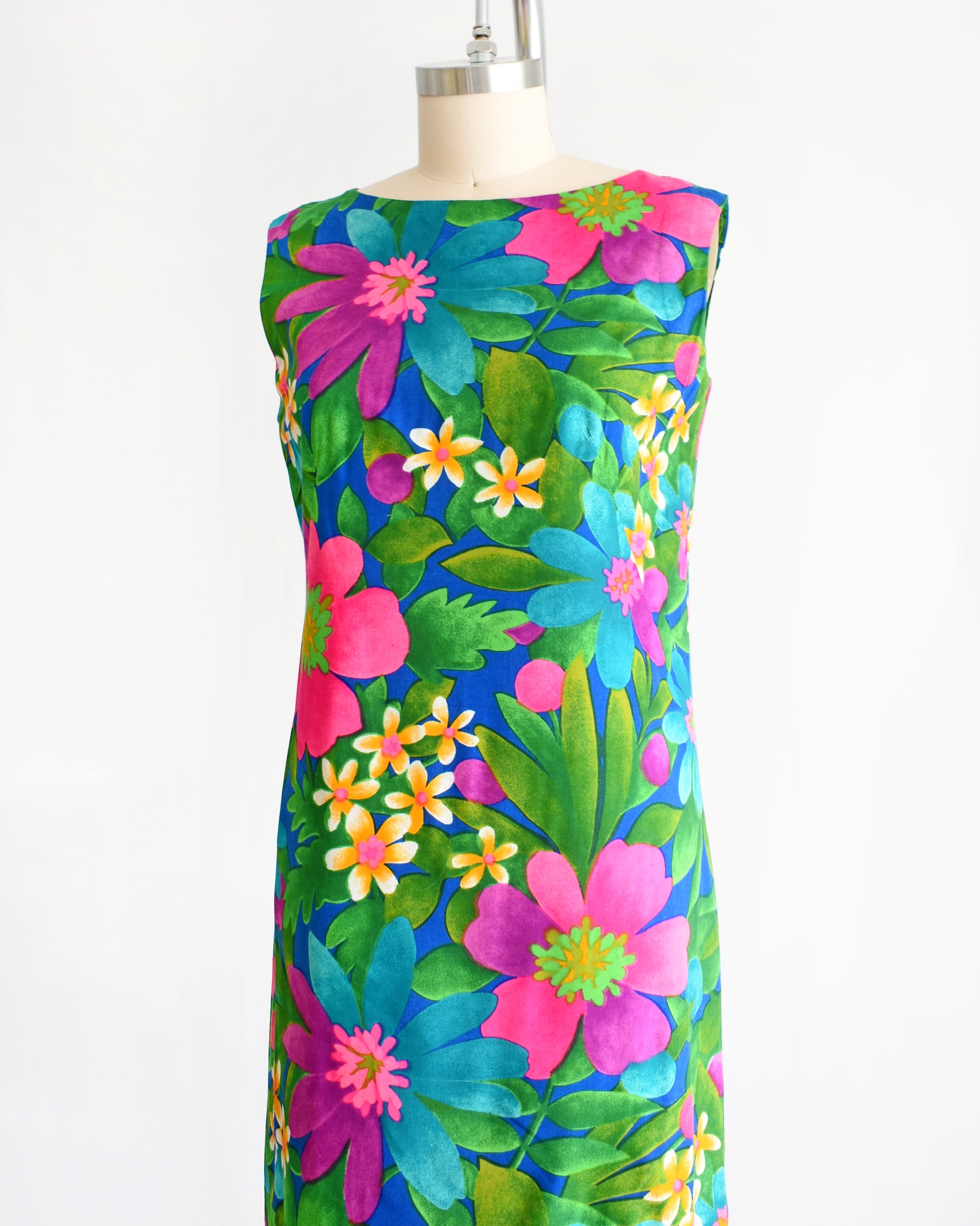 side front view of a vintage 1960s colorful floral dress on a mannequin against a white background