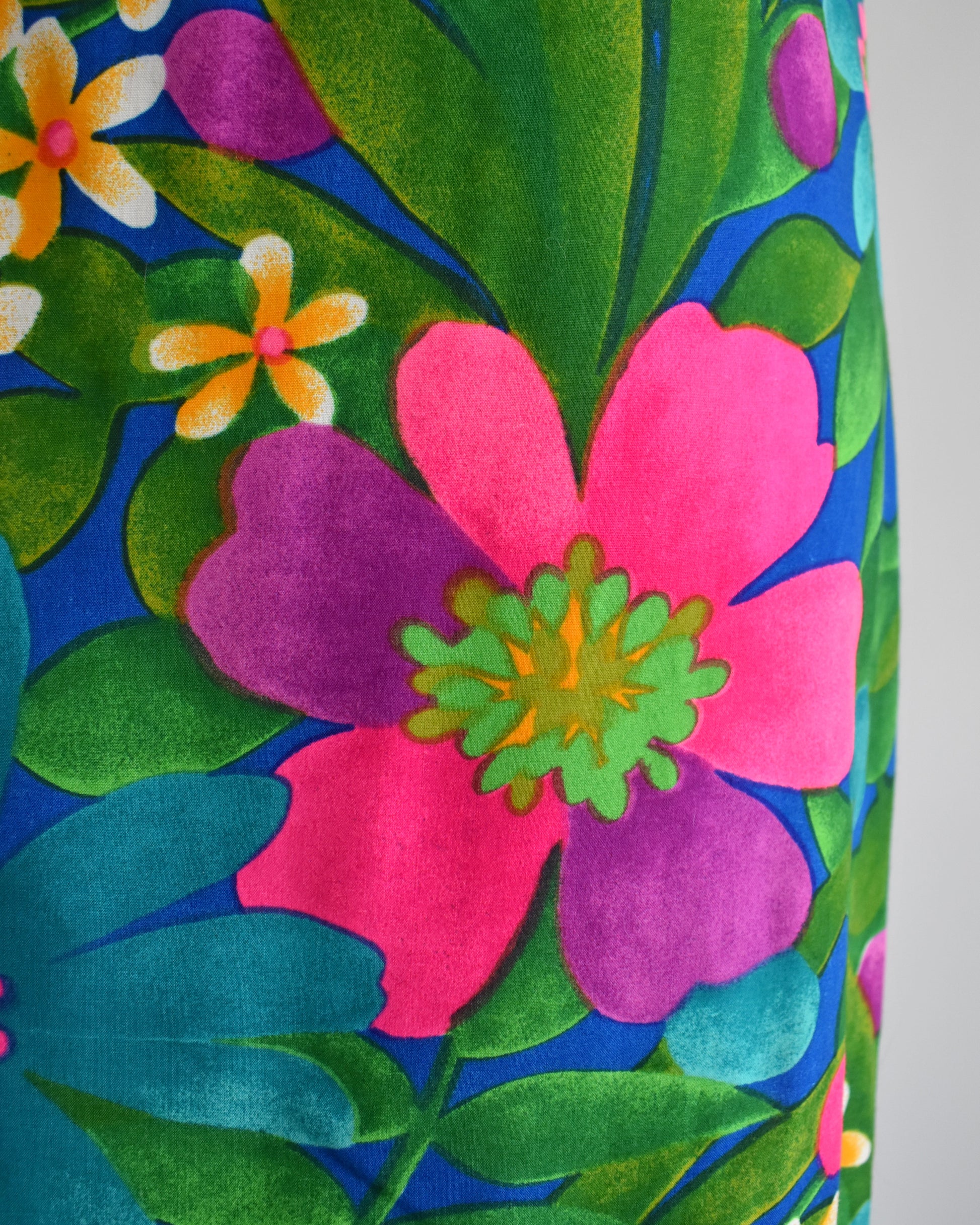 Close-up of a colorful floral pattern with pink and purple flowers on a blue background.