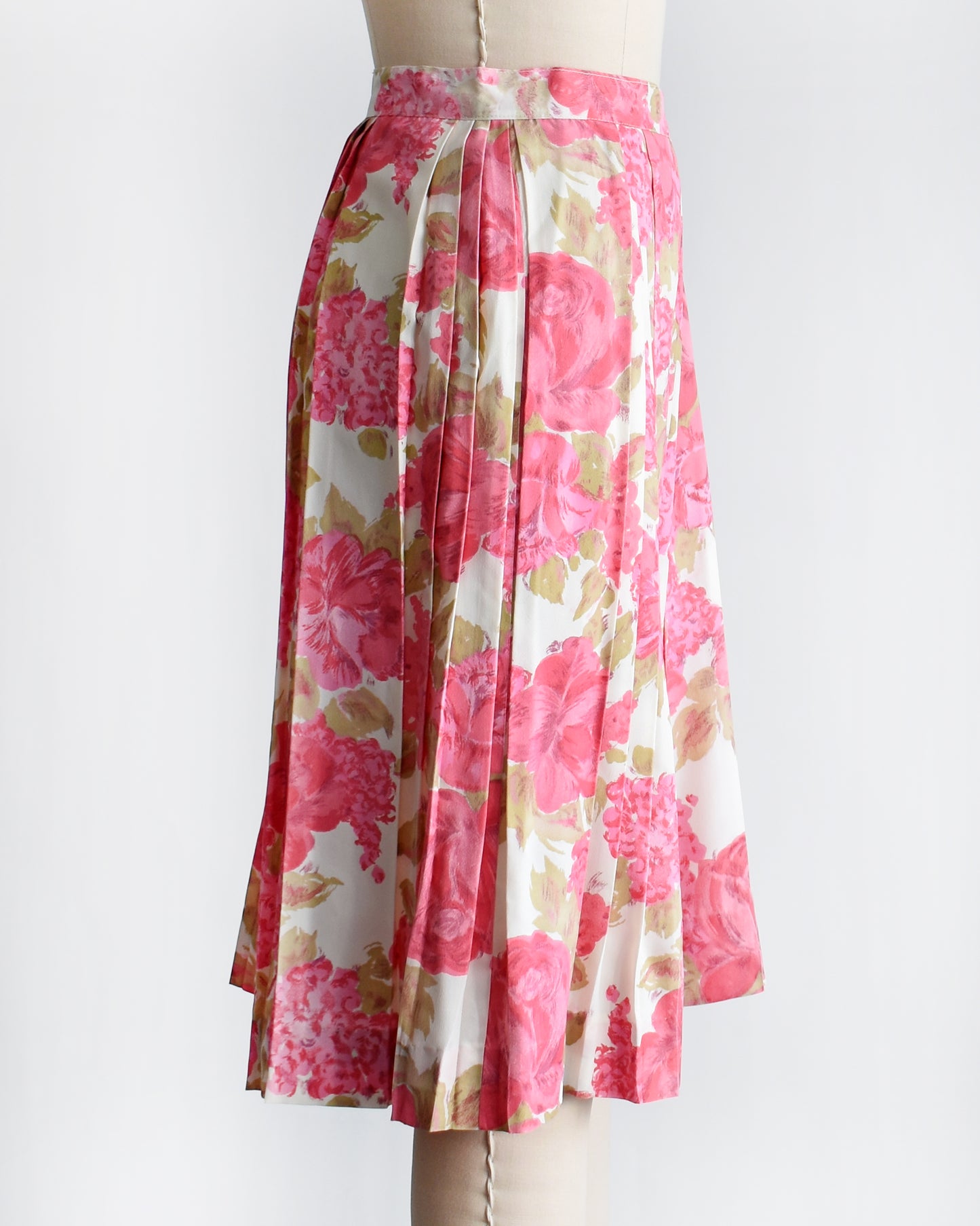 side view of a vintage 1950s pink floral skirt on a mannequin against a white background