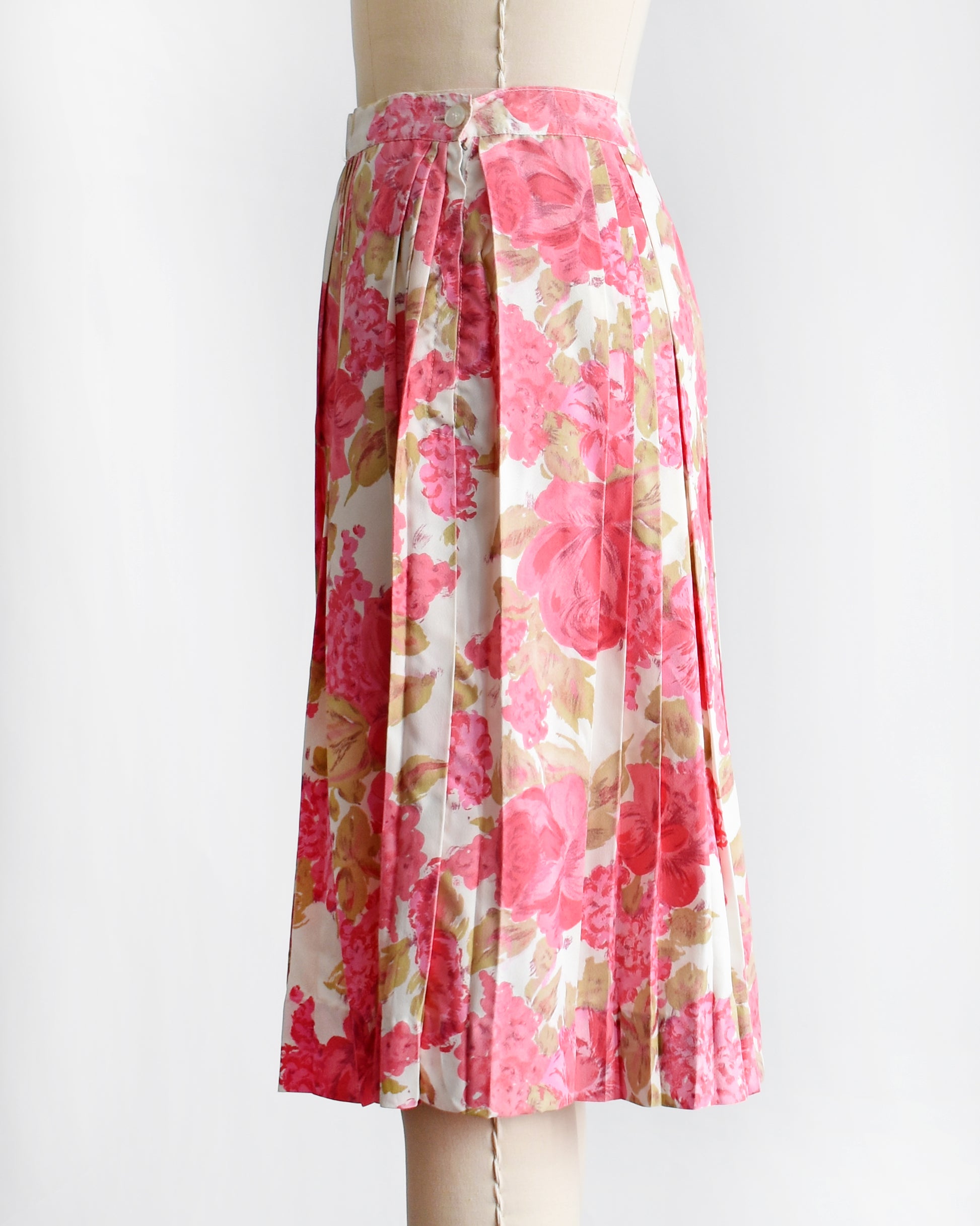 side view of a vintage 1950s pink floral skirt on a mannequin against a white background