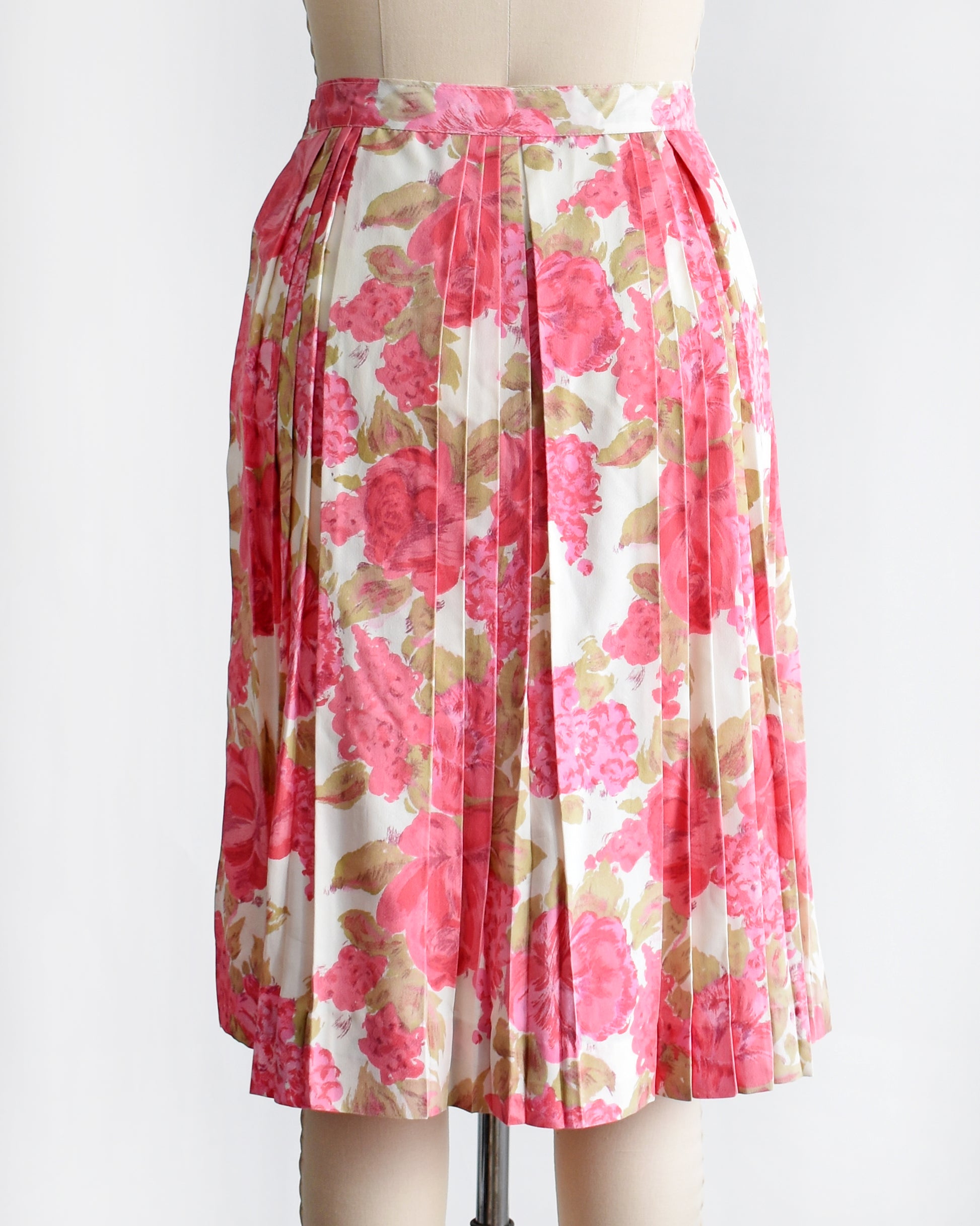 back view of a vintage 1950s pink floral skirt on a mannequin against a white background