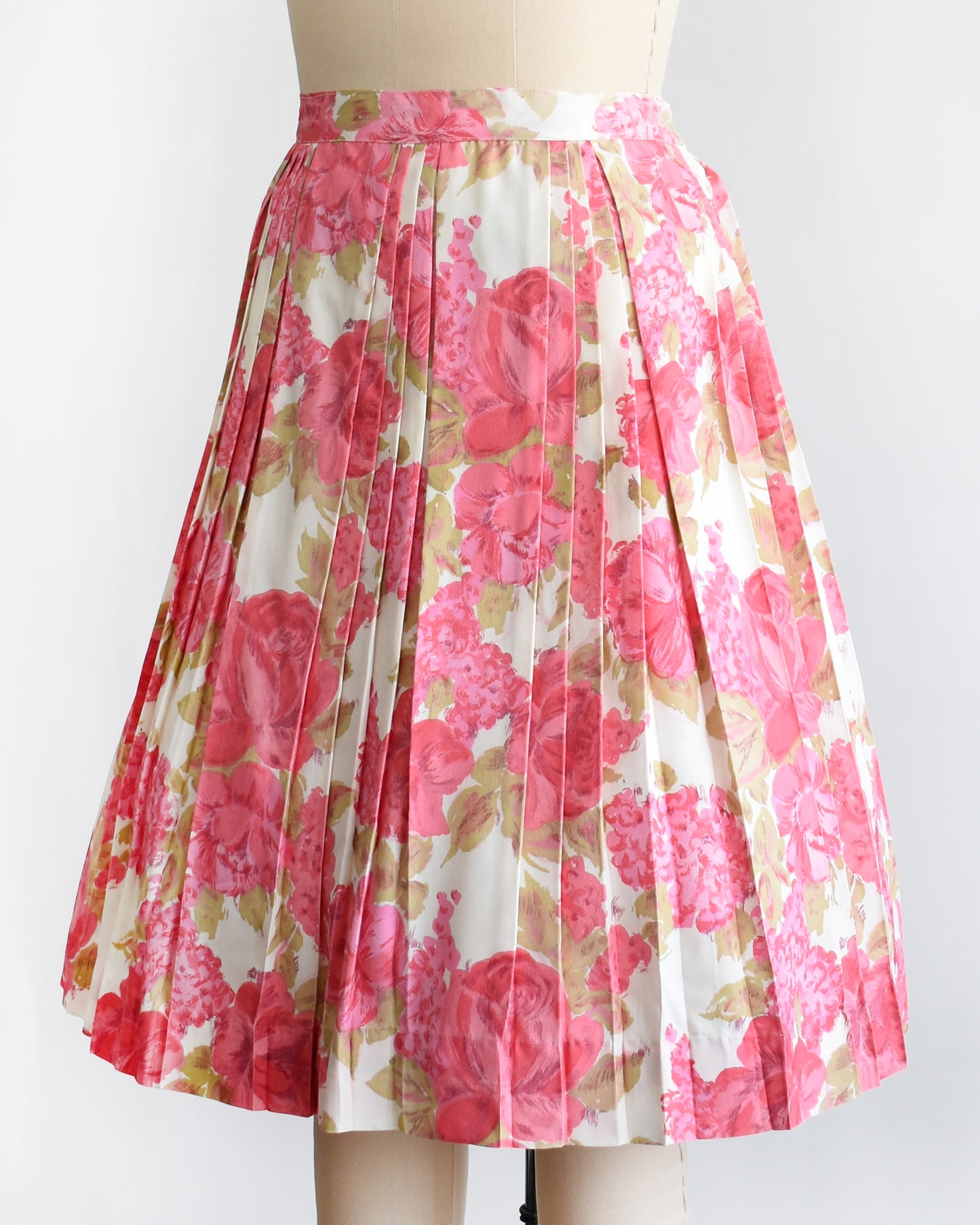 side front view of a vintage 1950s pink floral skirt on a mannequin against a white background