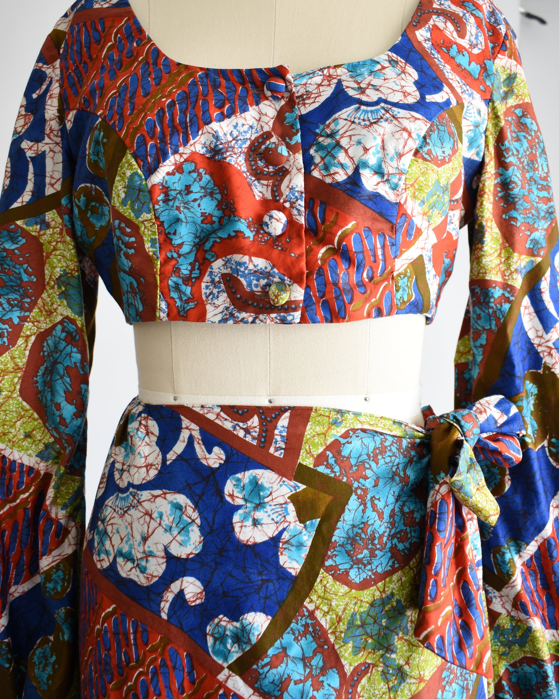 close up of the bodice and the waist of the skirt of a vintage 1960s/1970s Hawaiian two piece crop top and maxi skirt set by Kahala. 