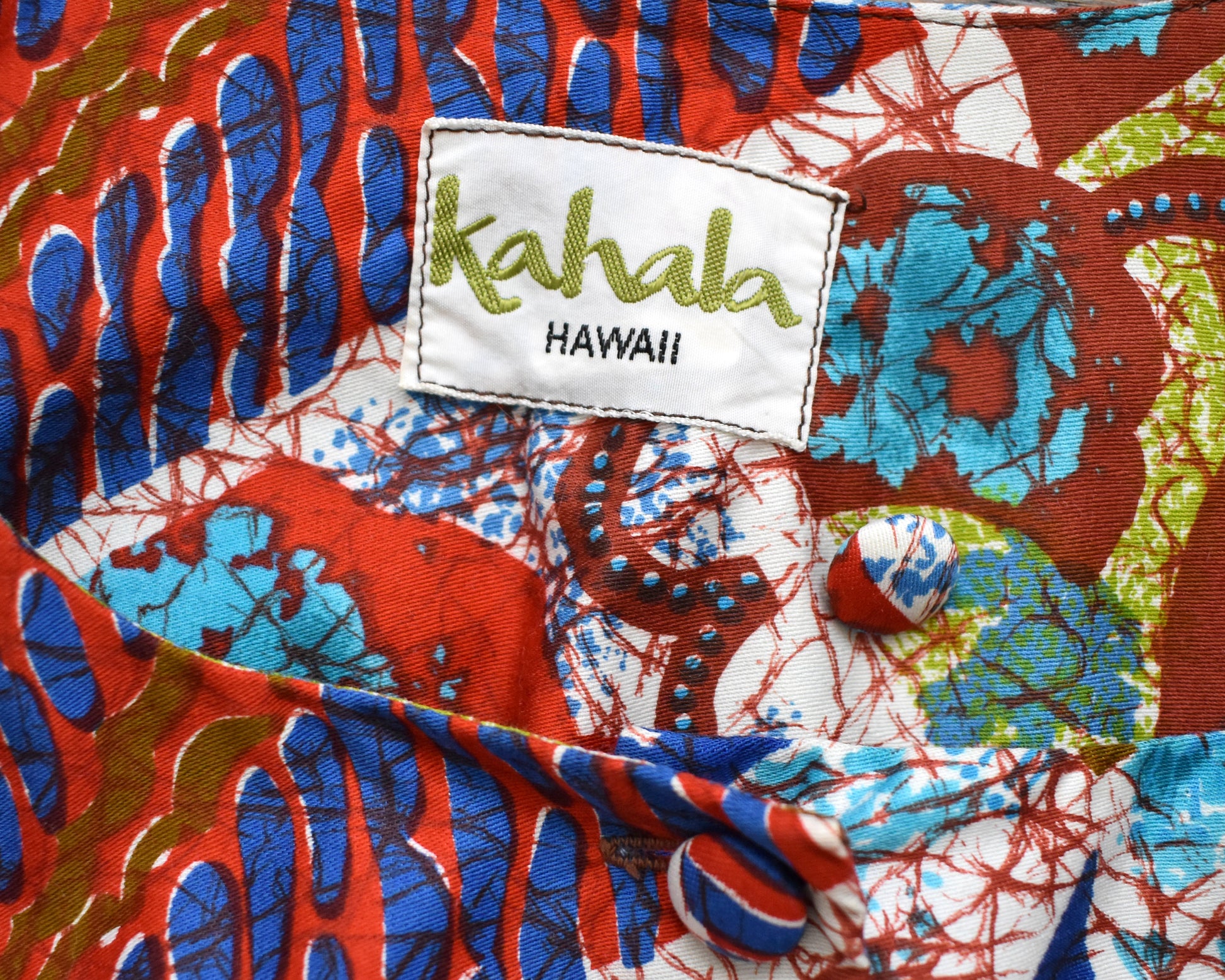close up of the tag which says Kahala Hawaii and an extra button