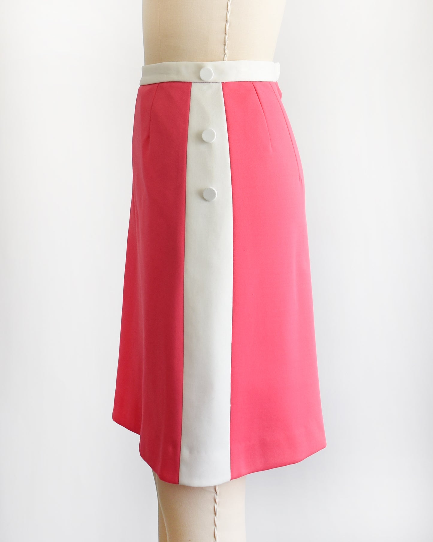 side view of a vintage 1970s pink and white skirt/skort with a white tulip design on a mannequin against a white background