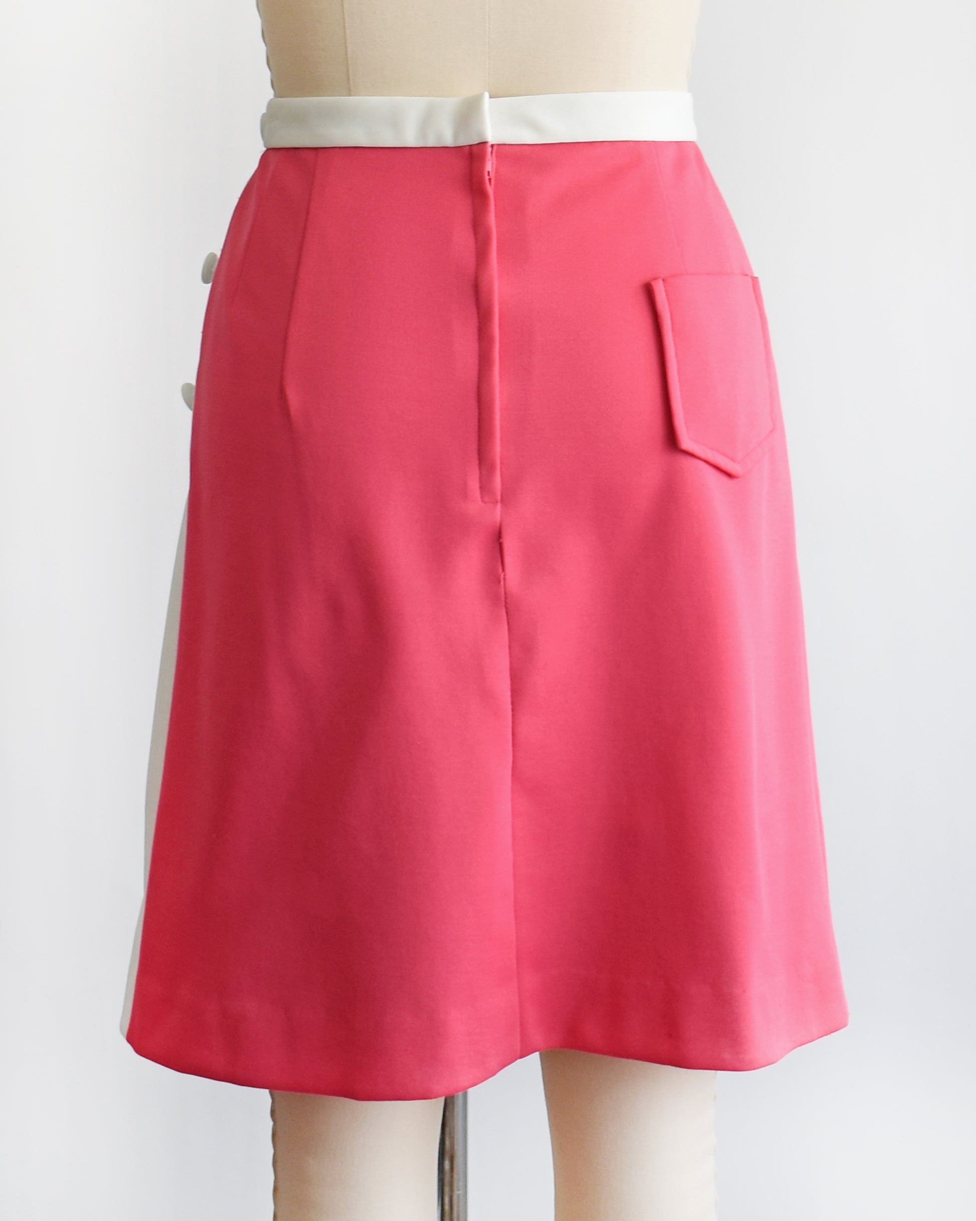 back view of a vintage 1970s pink skirt/skort with a white tulip design on a mannequin against a white background