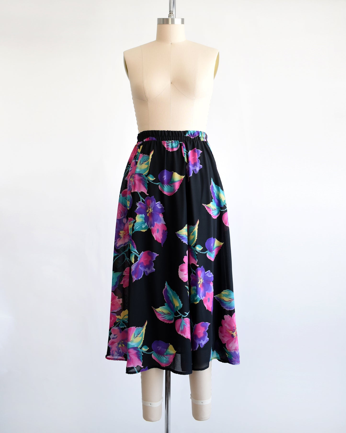 vintage 1990s black skirt with colorful floral pattern on a mannequin against a white background