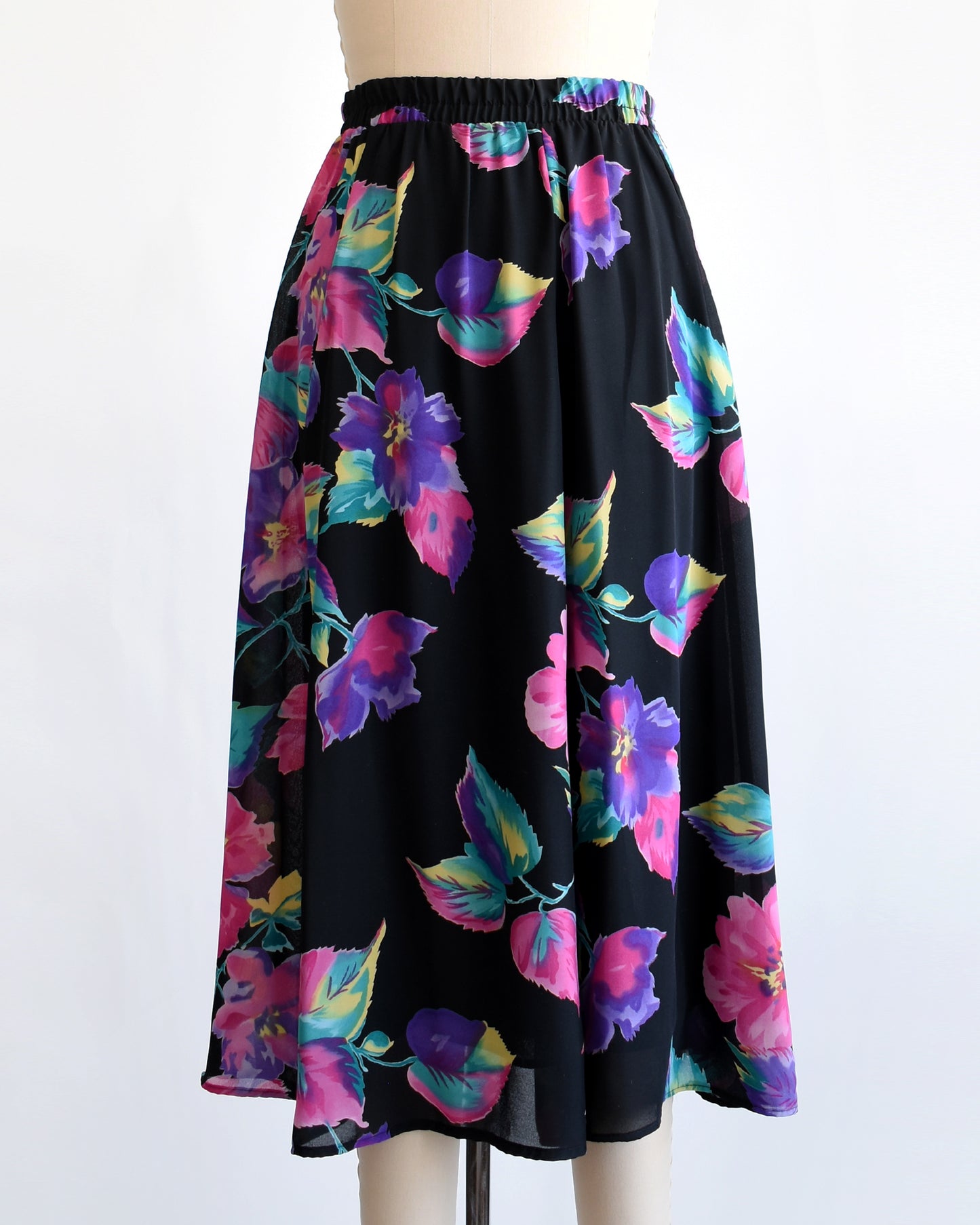 vintage 1990s black skirt with colorful floral pattern on a mannequin against a white background