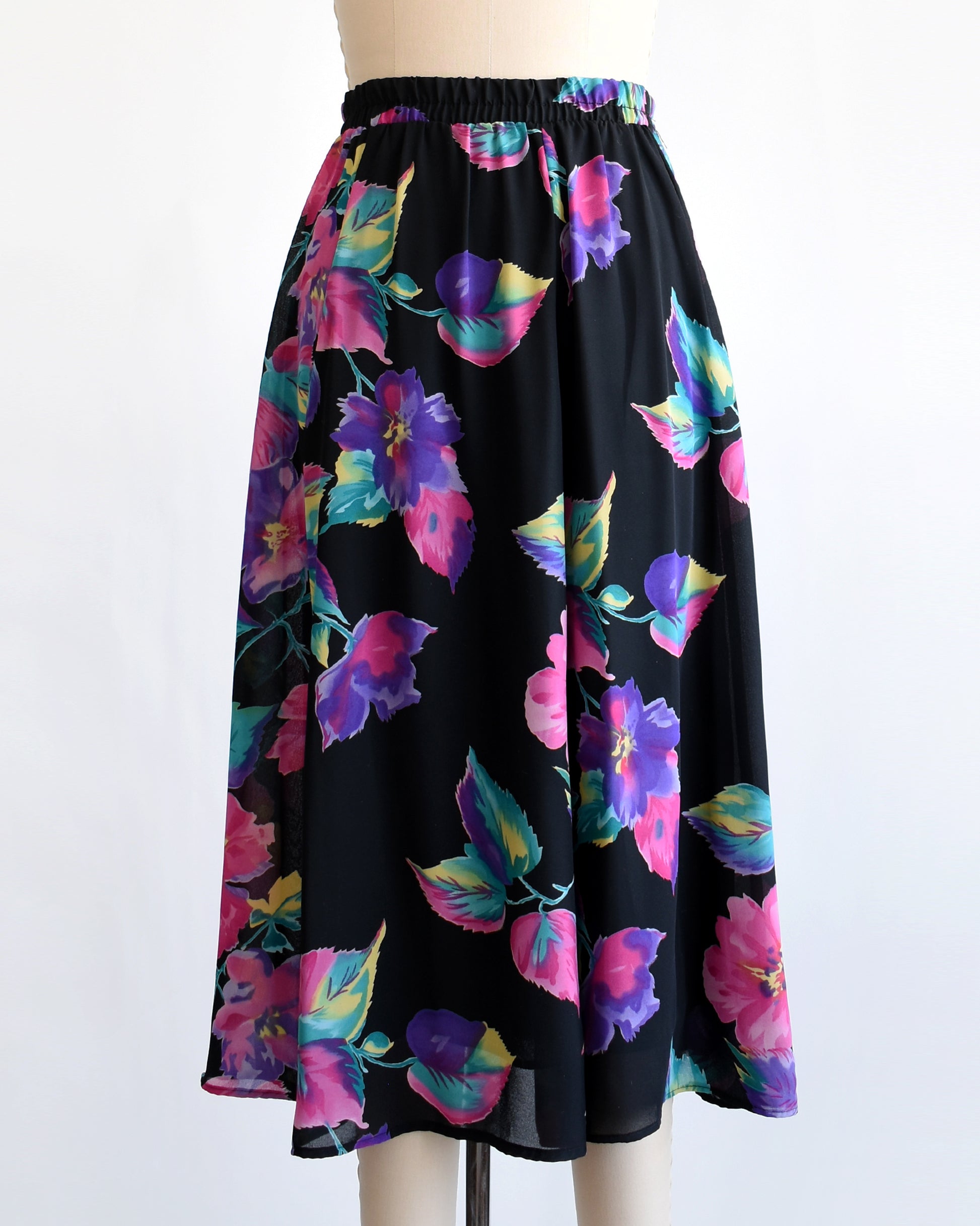 vintage 1990s black skirt with colorful floral pattern on a mannequin against a white background