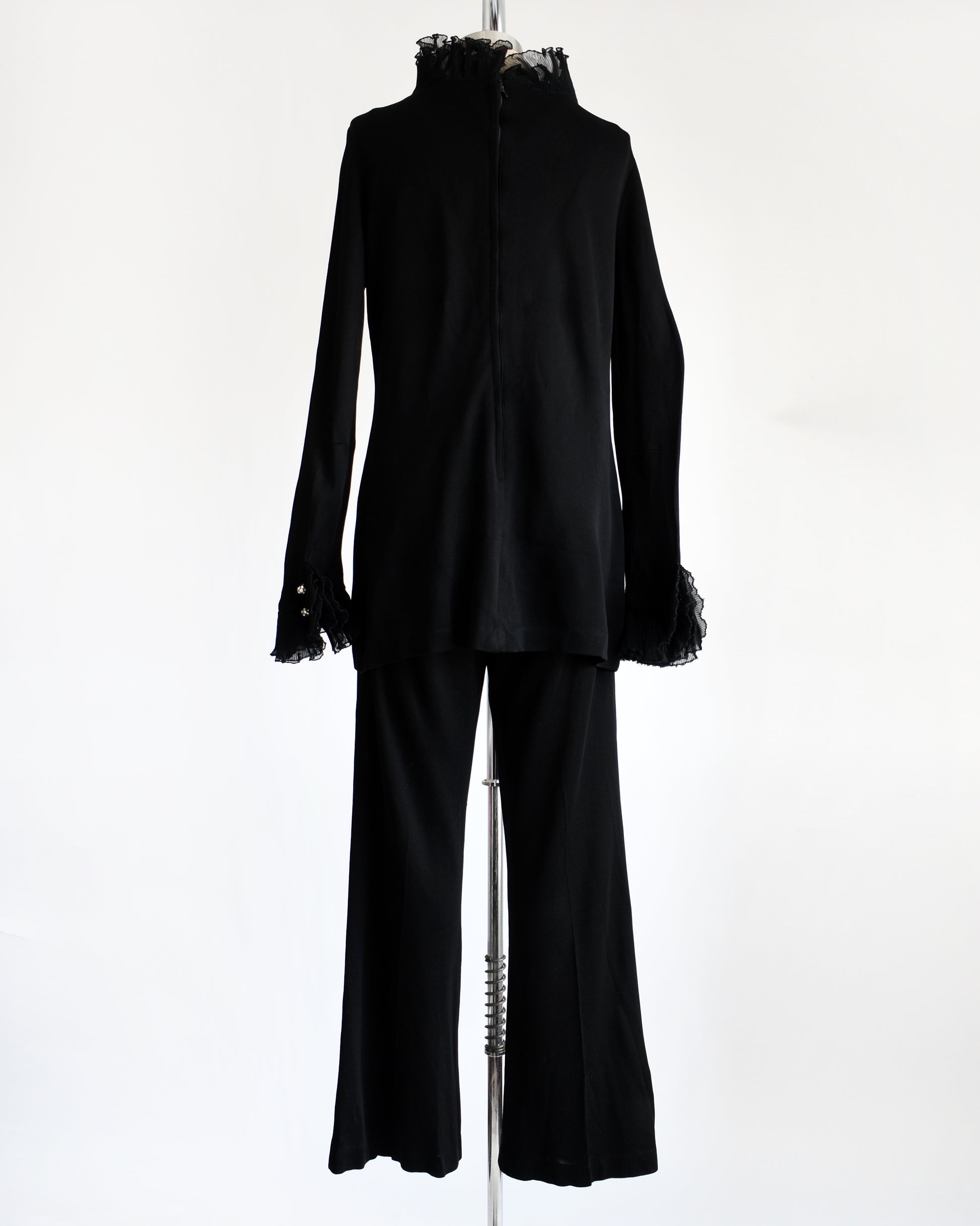 back view of a vintage 1970s black ruffled pant set with decorative rhinestone buttons