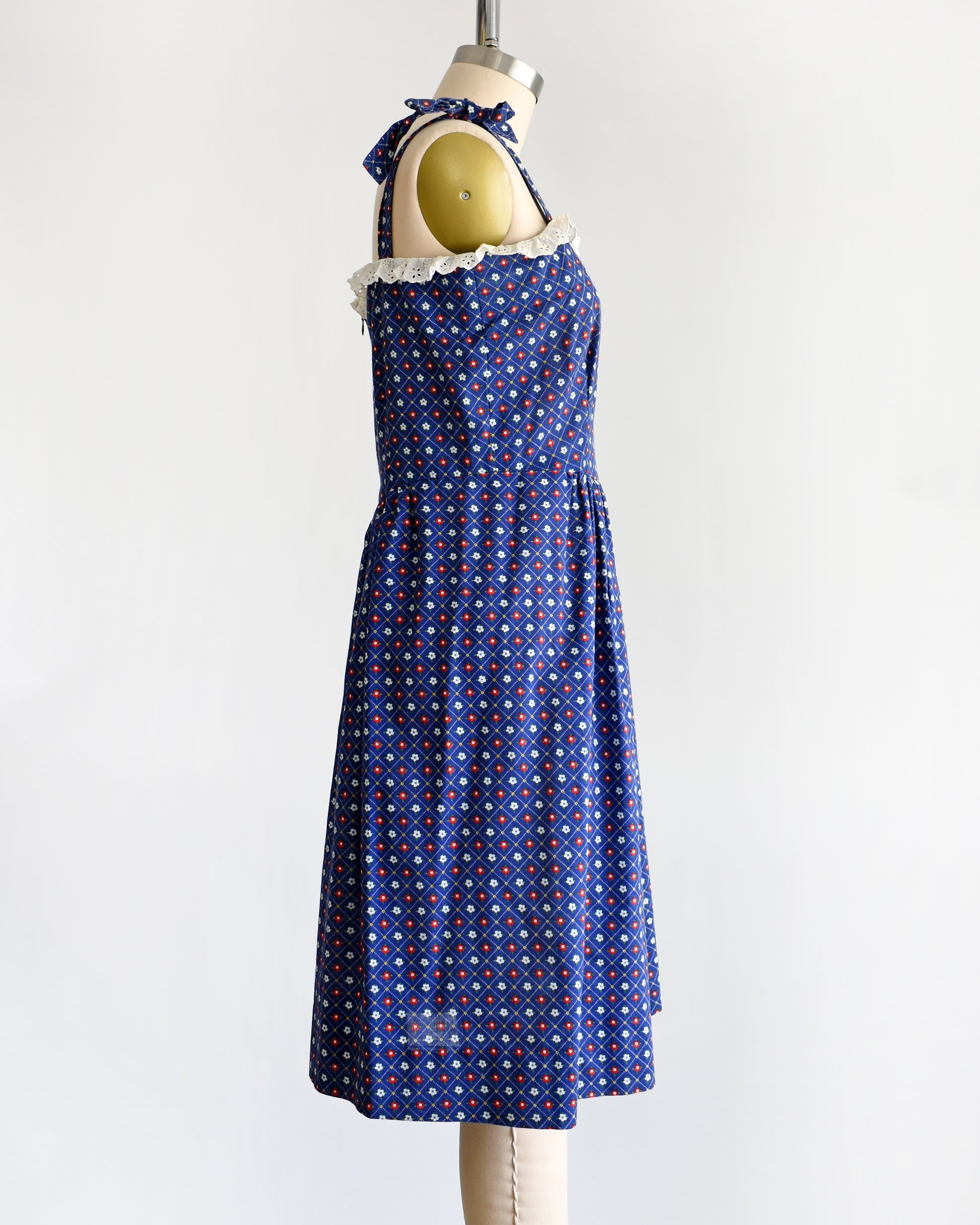 side view of a vintage 1970s navy blue floral sundress on a dress form