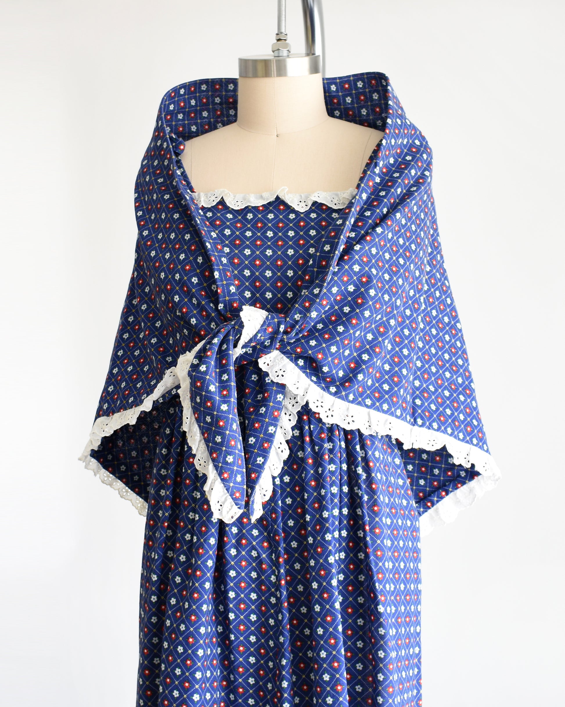 side front view of a vintage 1970s navy blue floral sundress with matching shawl on a dress form
