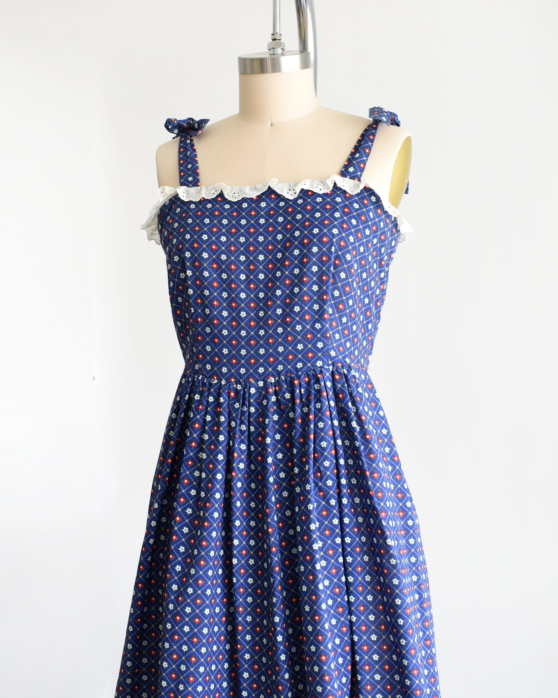 side front view of a vintage 1970s navy blue floral sundress on a dress form