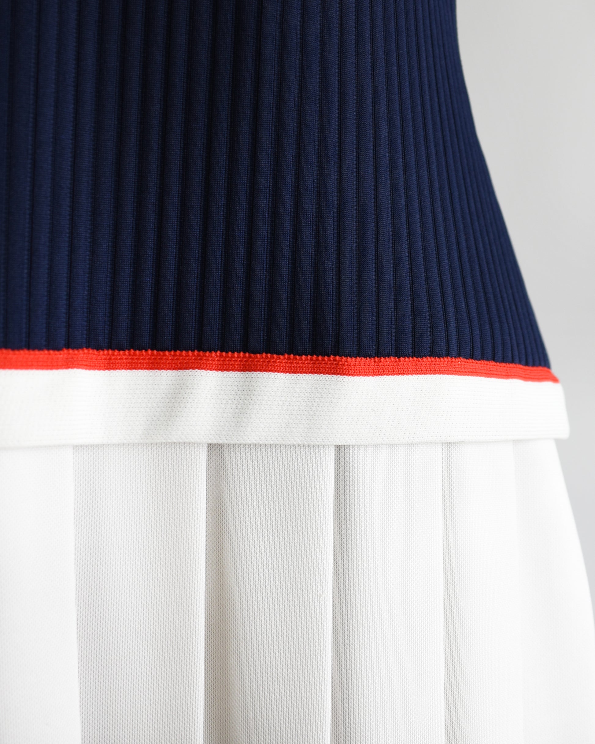 Close-up of a skirt with navy, red, and white colors on a light gray background