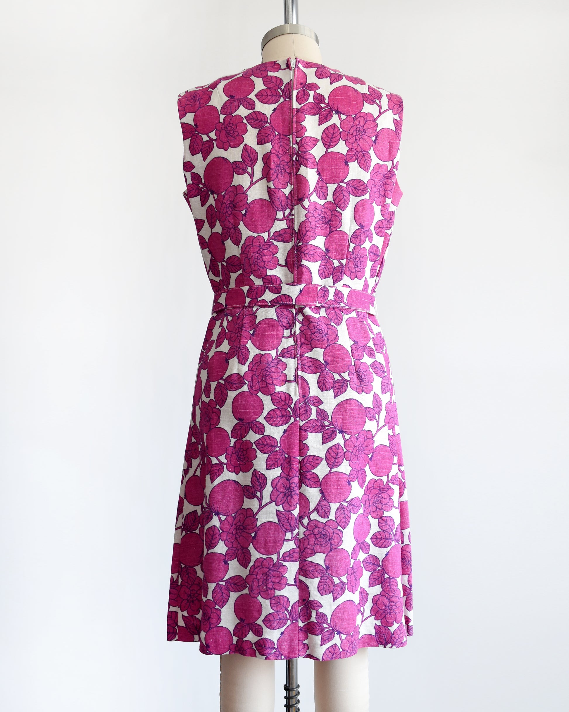 back view of a vintage 1960s magenta and white floral and fruit print dress