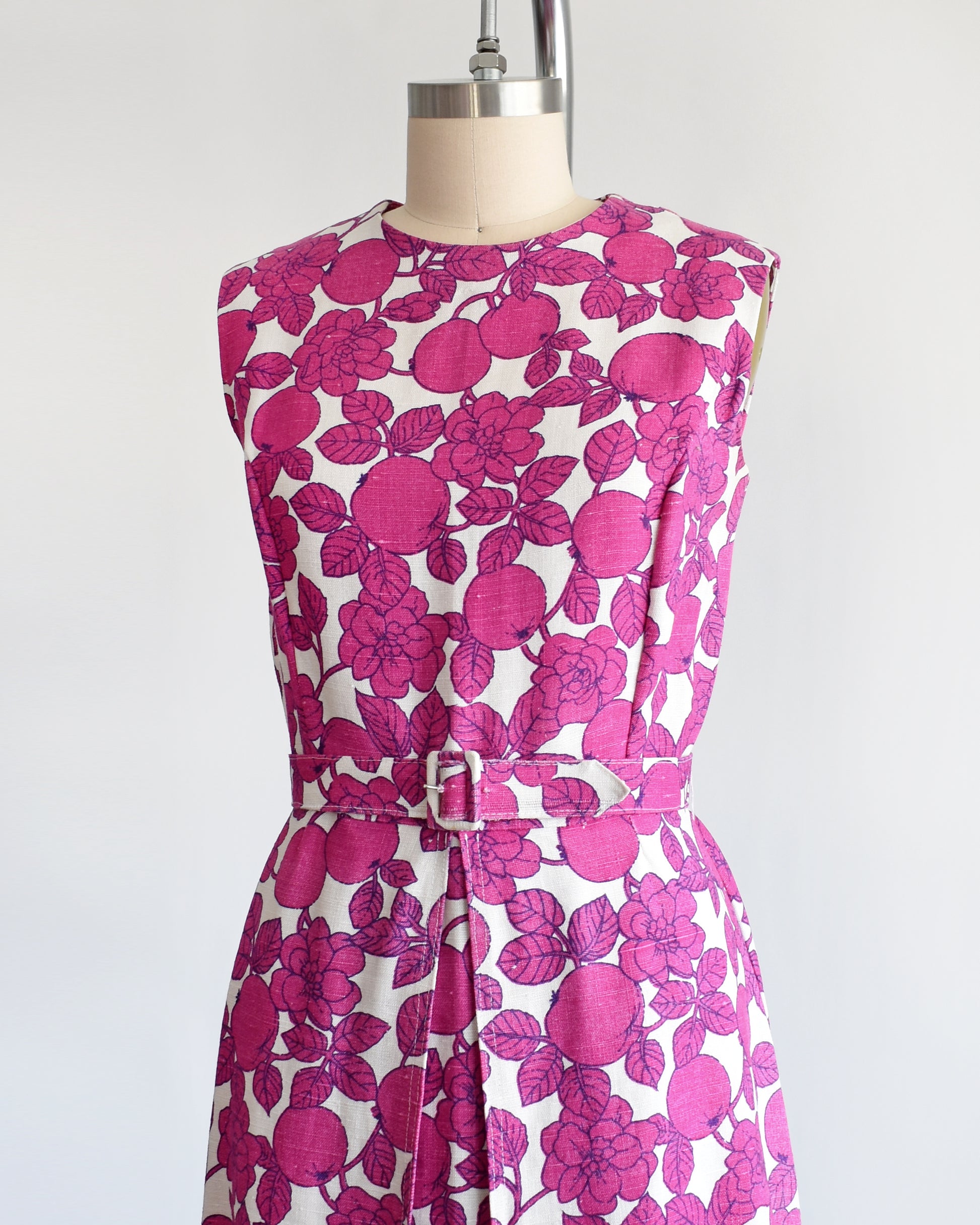 side front view of a vintage 1960s magenta and white floral and fruit print dress