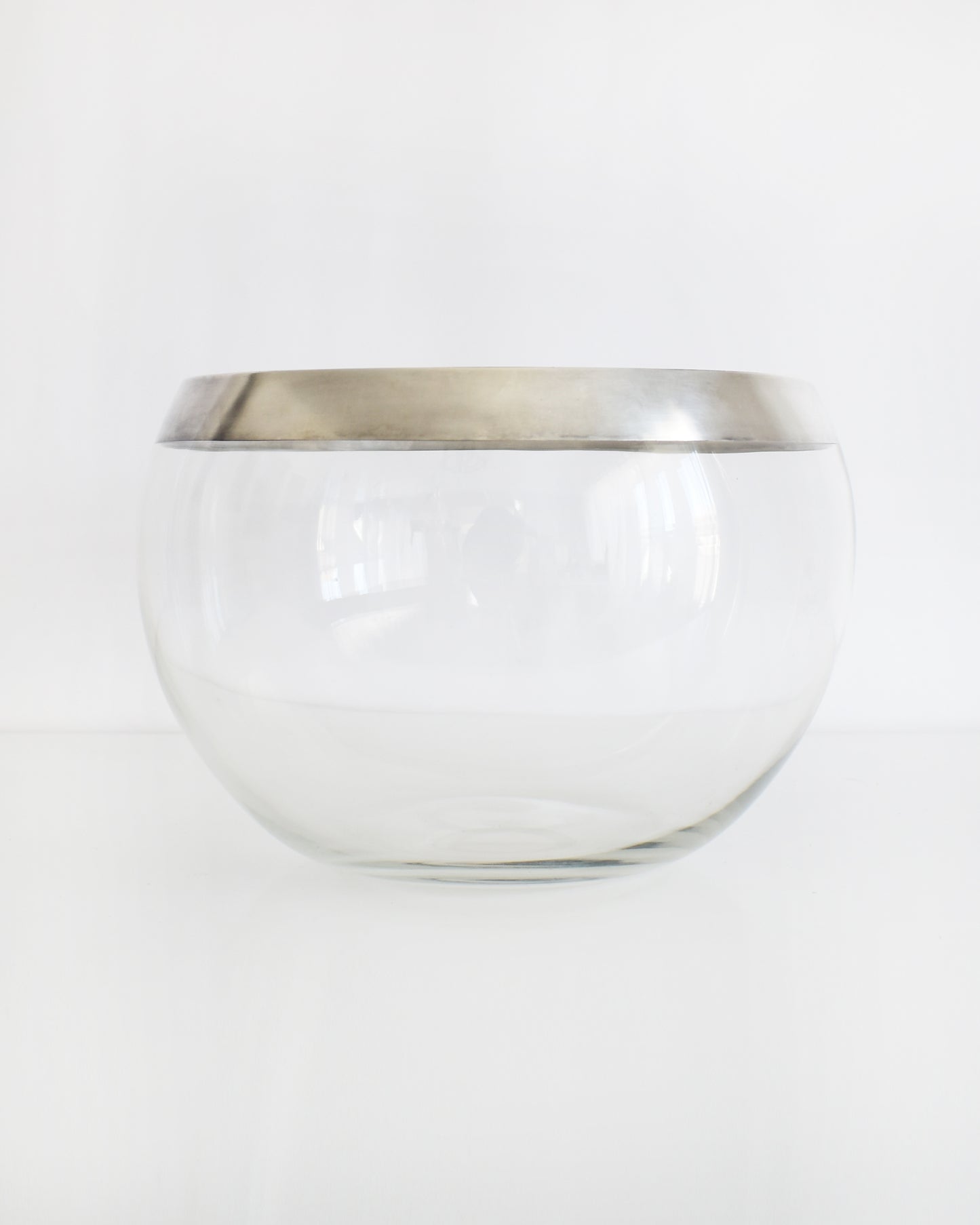 a vintage silver rim clear glass punch bowl on a white background