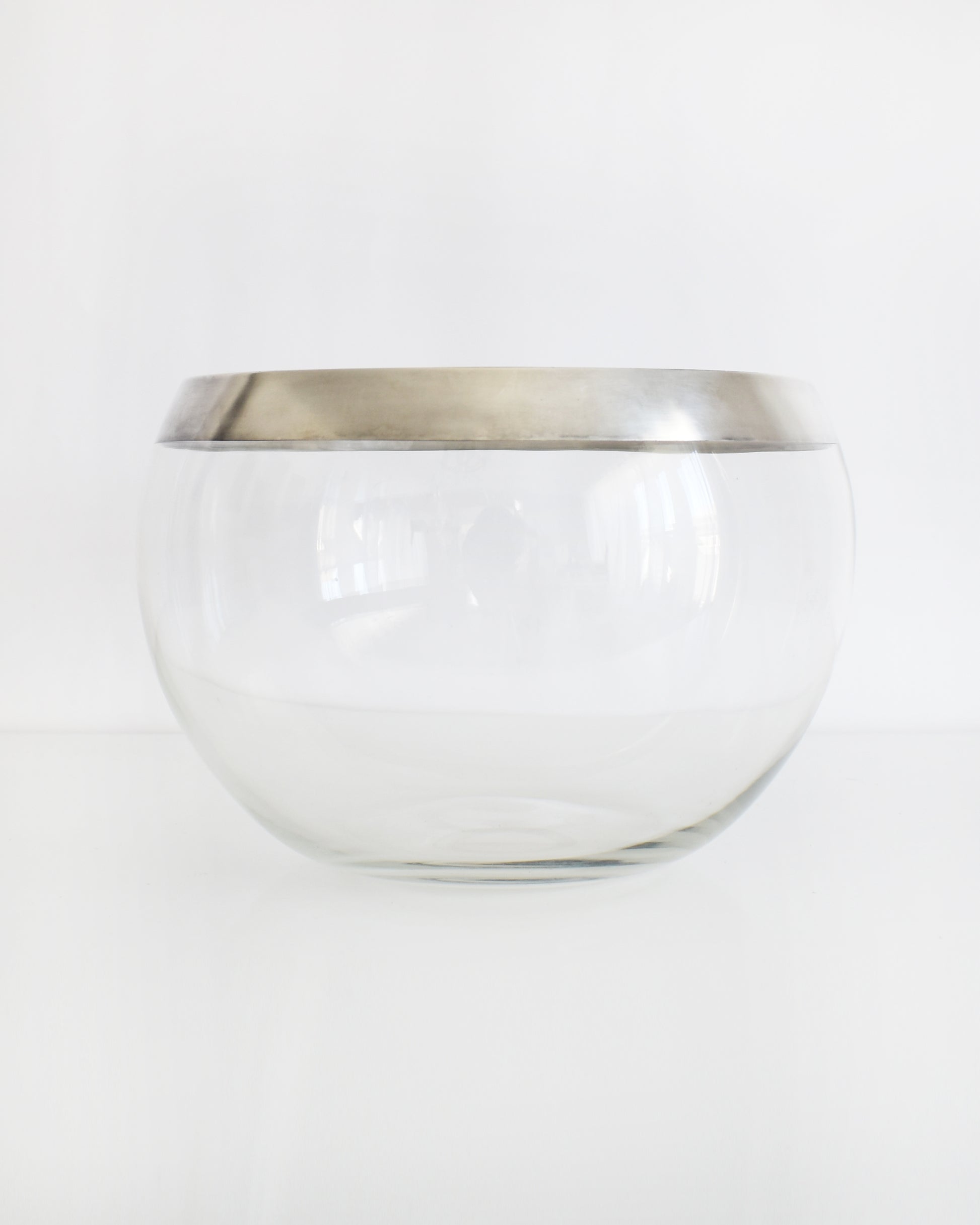 a vintage silver rim clear glass punch bowl on a white background