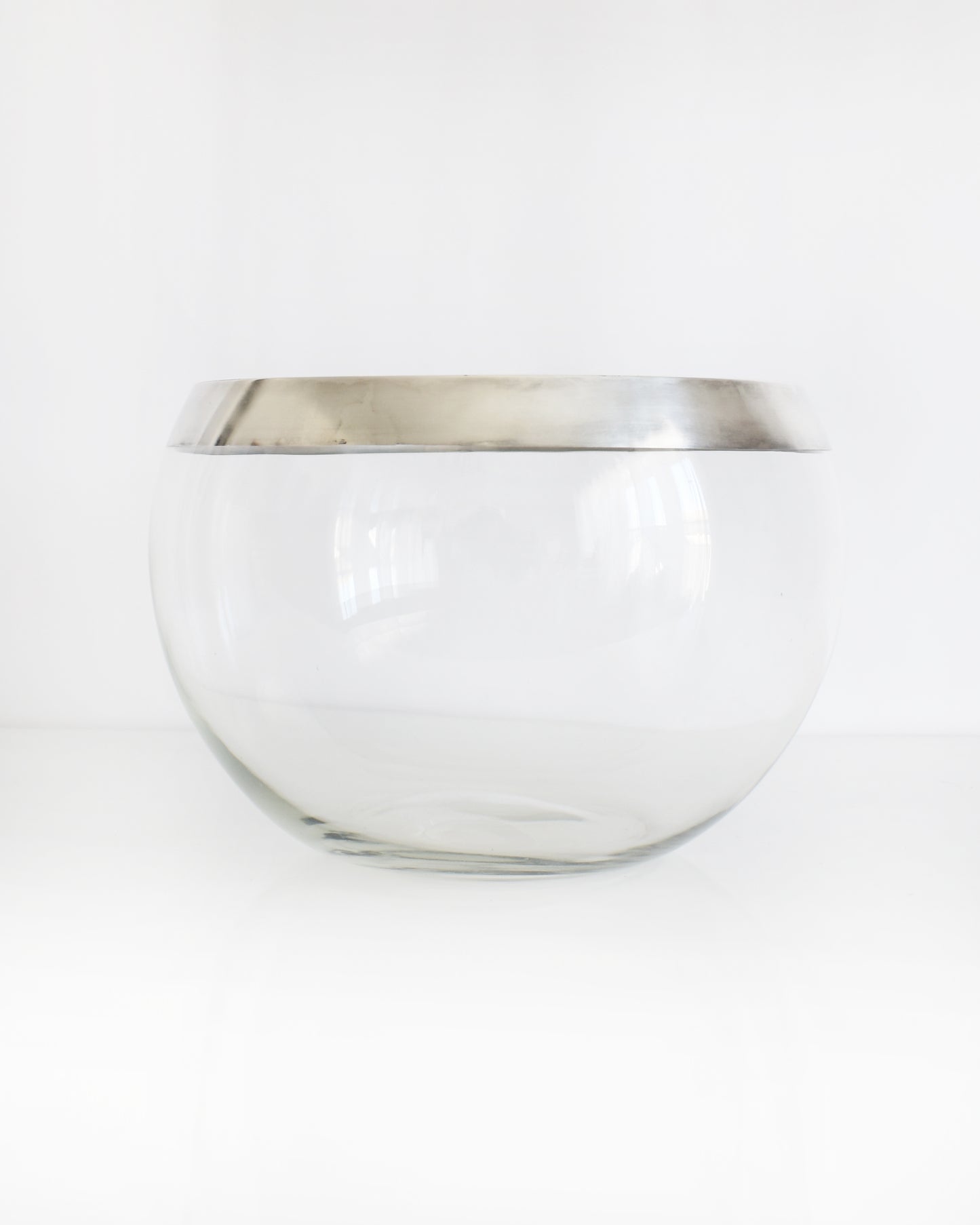 a vintage silver rim clear glass punch bowl on a white background