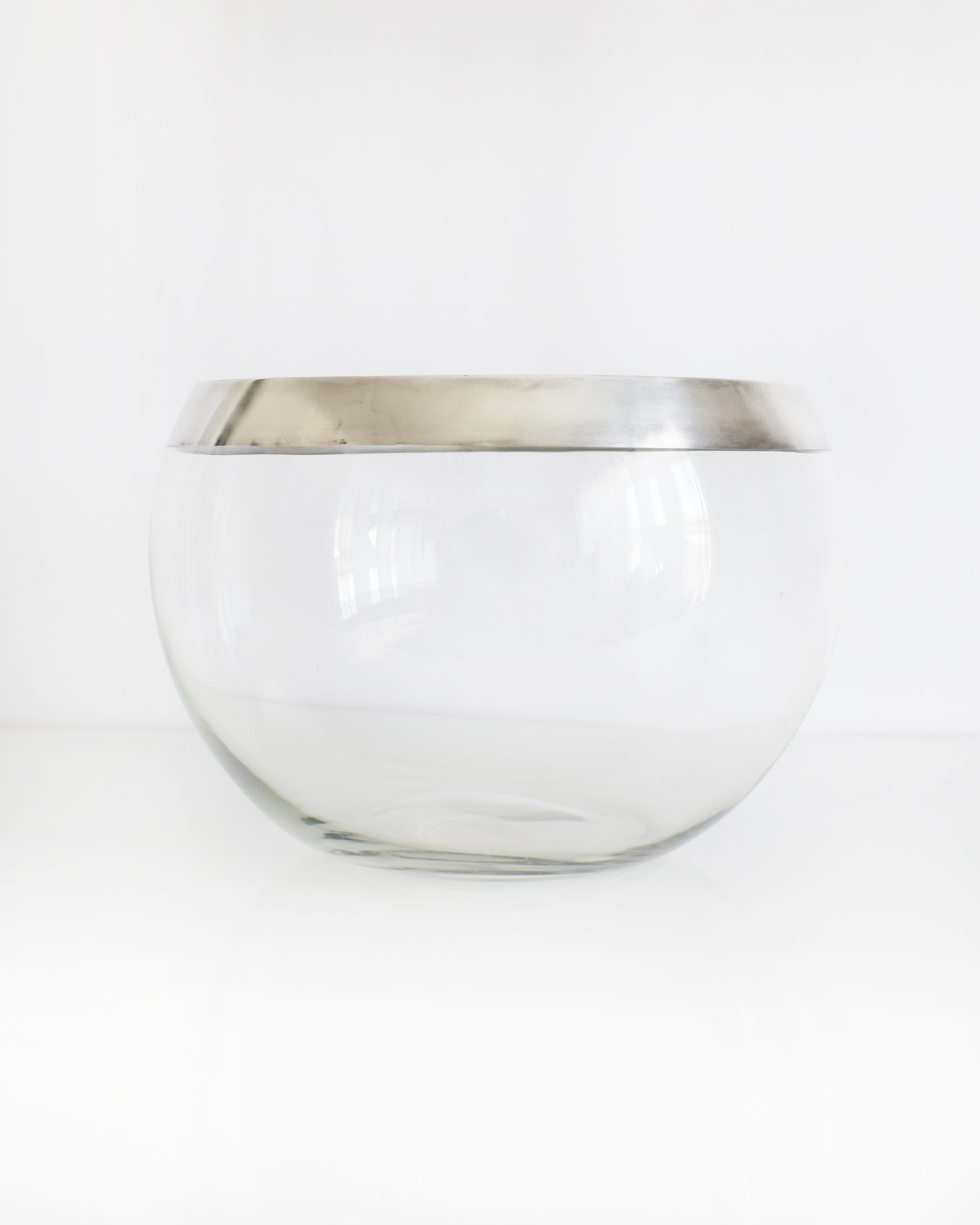 a vintage silver rim clear glass punch bowl on a white background