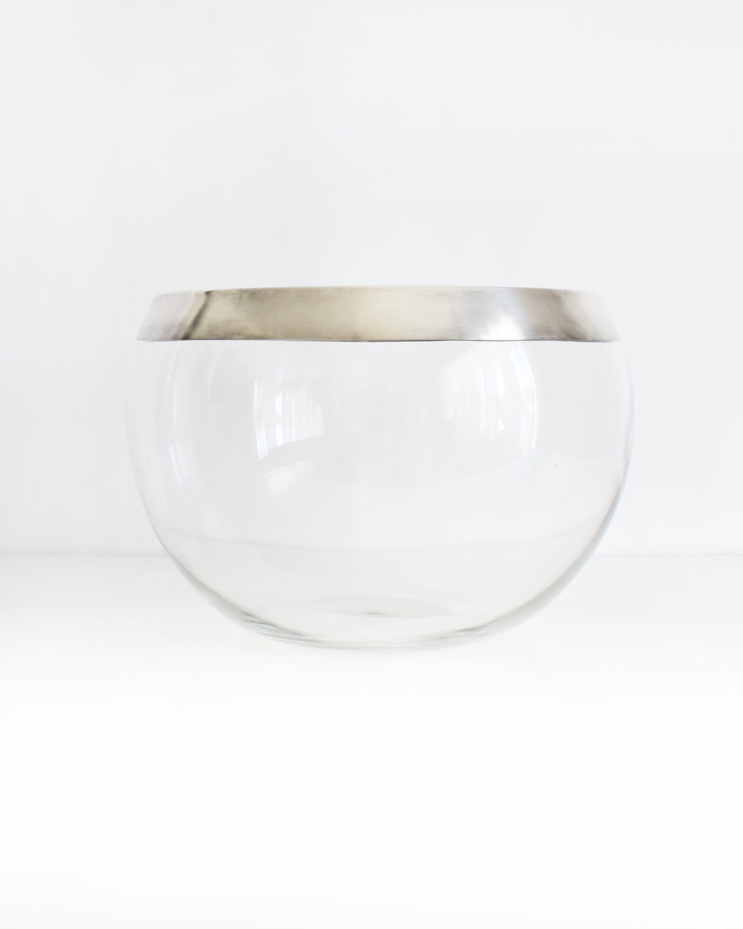 a vintage silver rim clear glass punch bowl on a white background