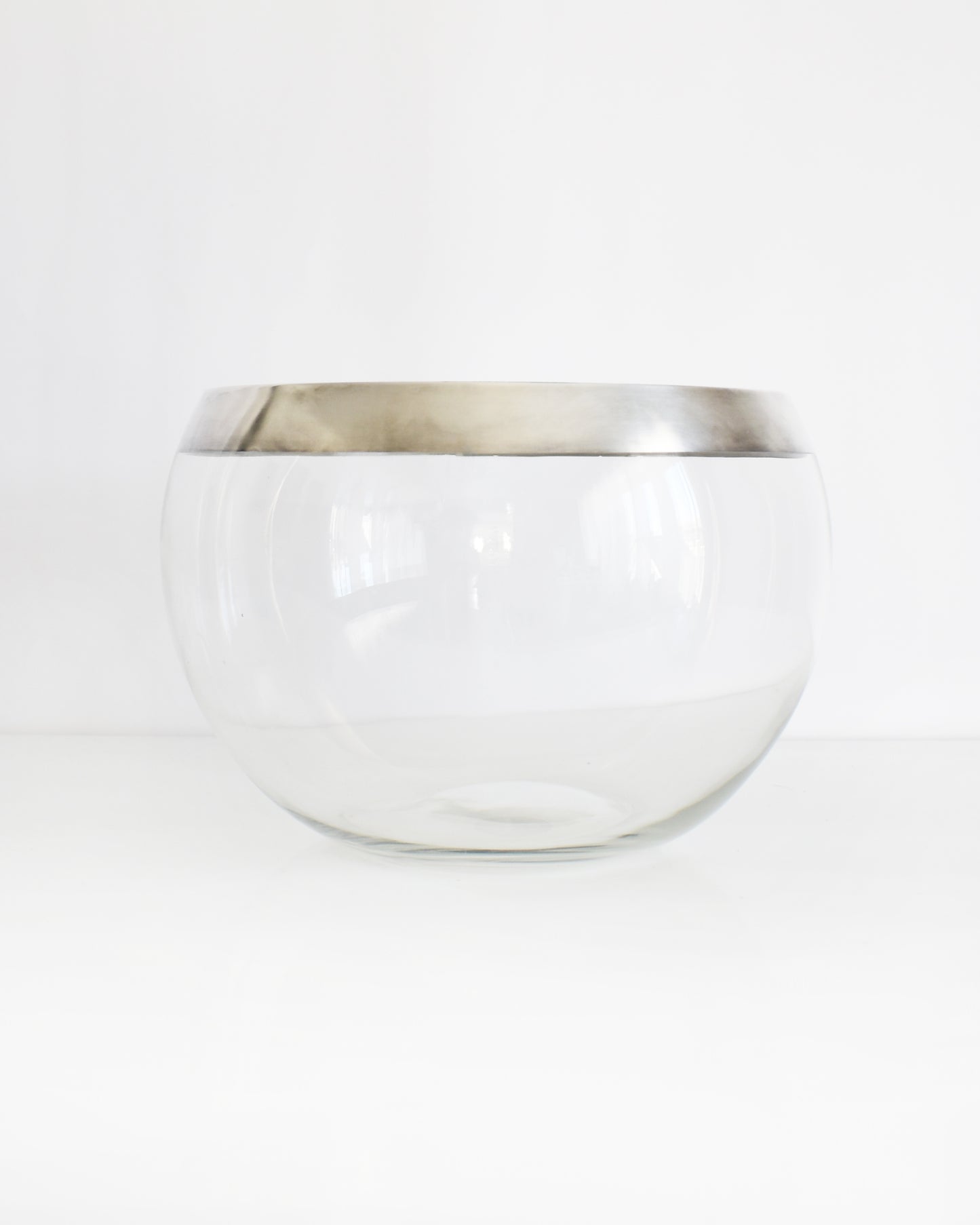 a vintage silver rim clear glass punch bowl on a white background