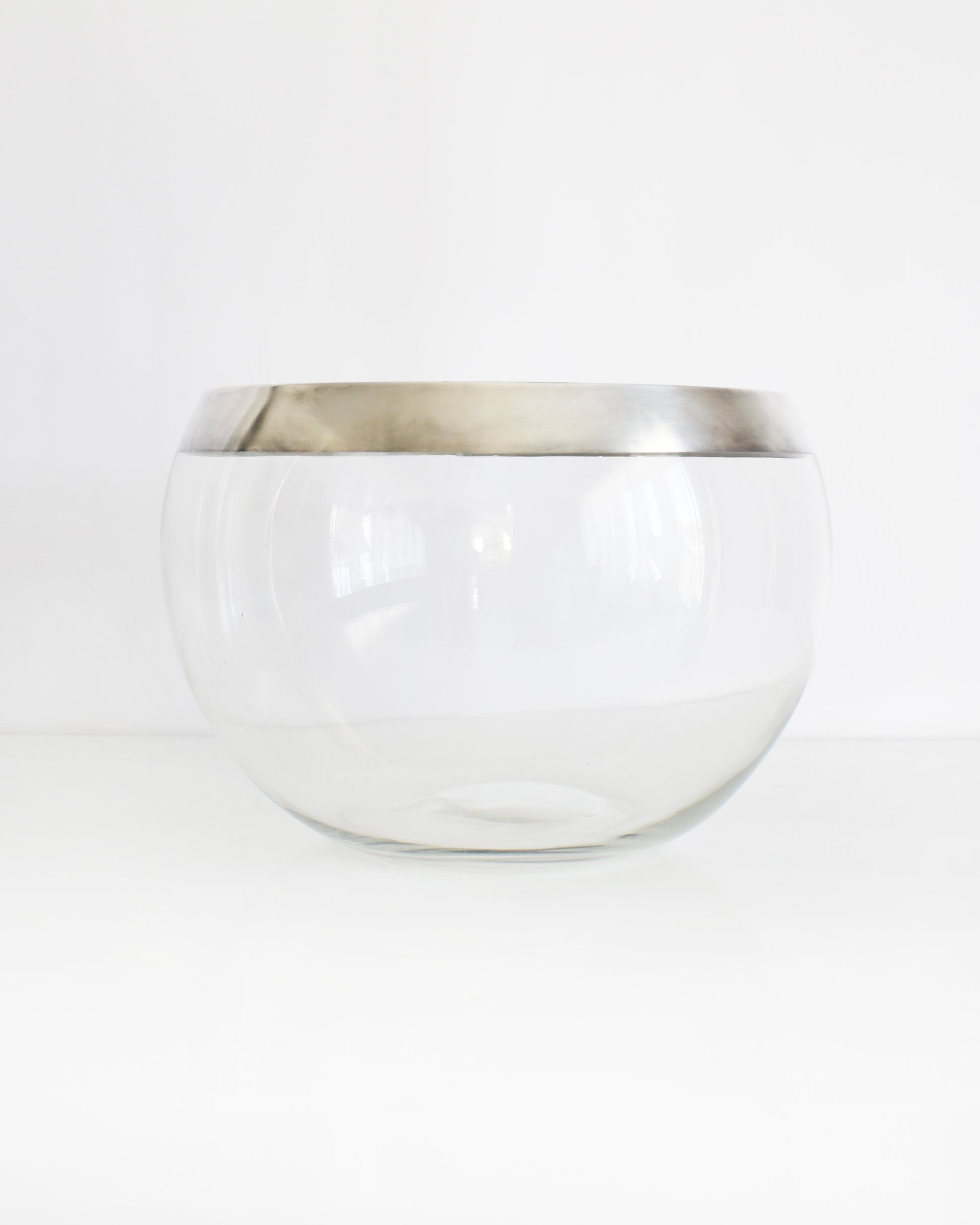 a vintage silver rim clear glass punch bowl on a white background