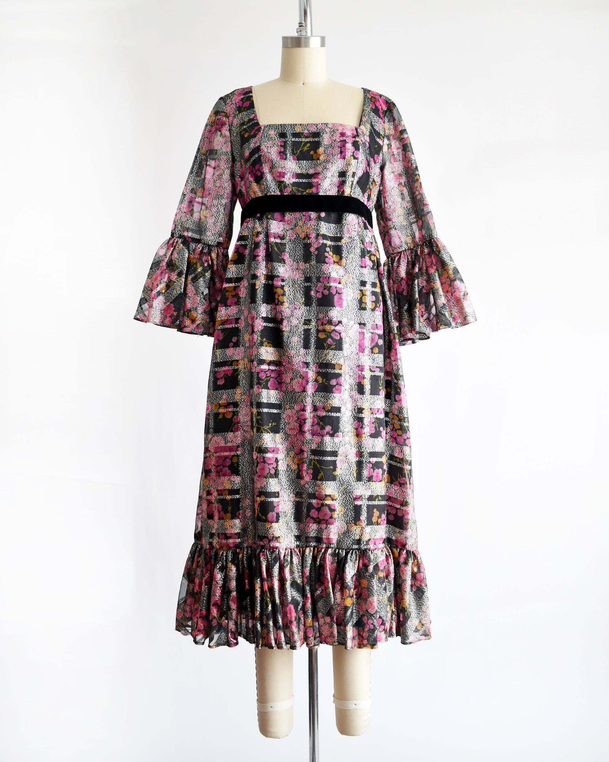 a vintage 1970s pink and black floral Victor Costa dress on a mannequin against a white background