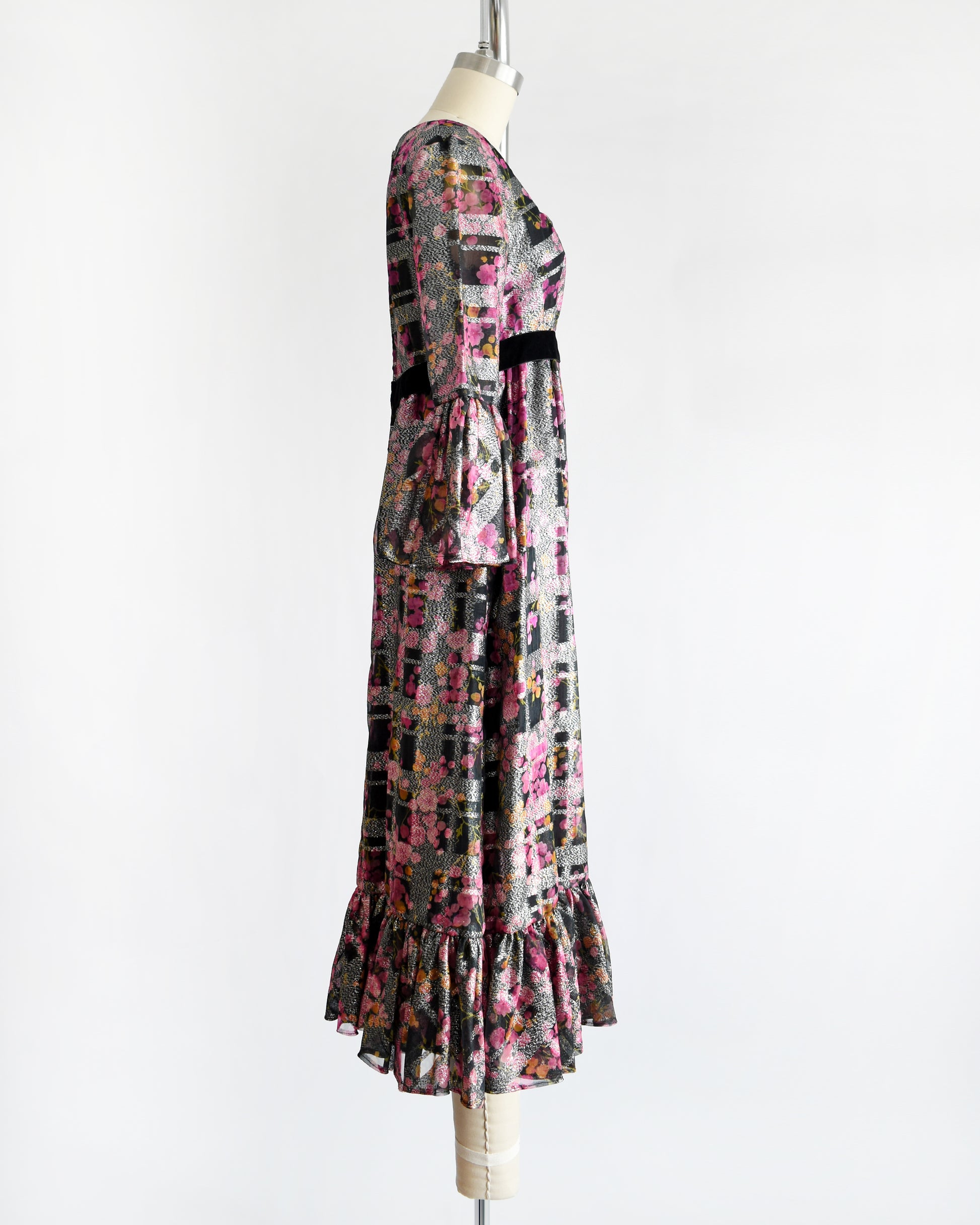 side view of a vintage 1970s pink and black floral Victor Costa dress on a mannequin against a white background