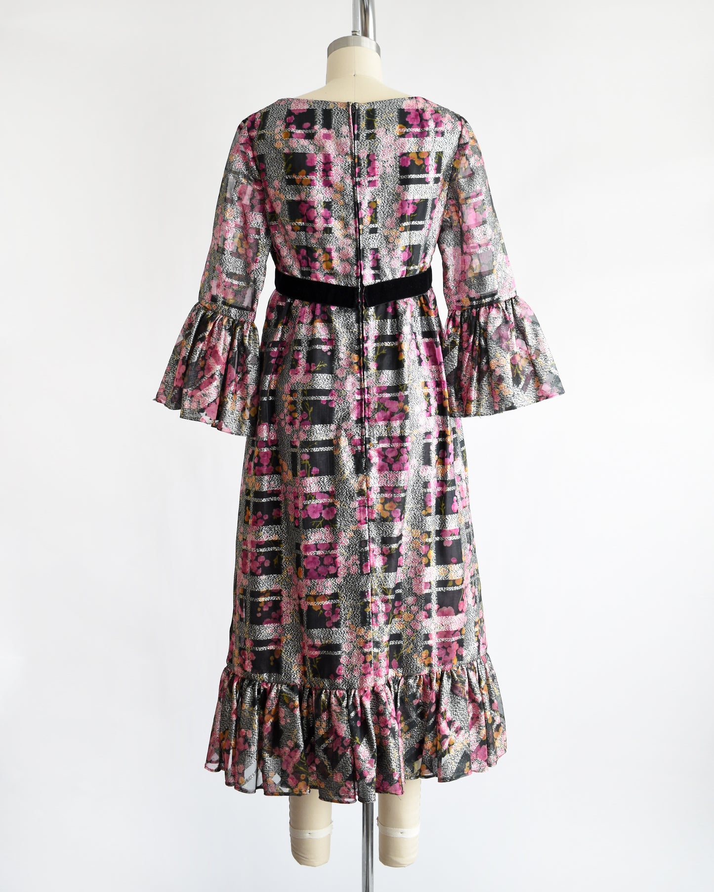 back view of a vintage 1970s pink and black floral Victor Costa dress on a mannequin against a white background