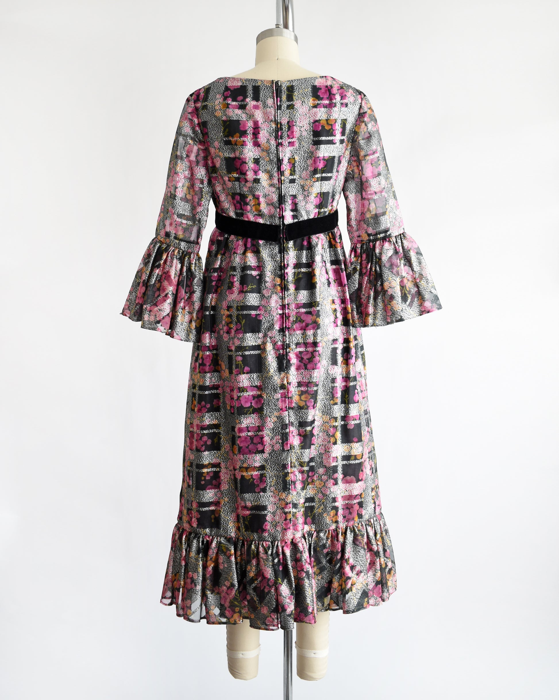 back view of a vintage 1970s pink and black floral Victor Costa dress on a mannequin against a white background