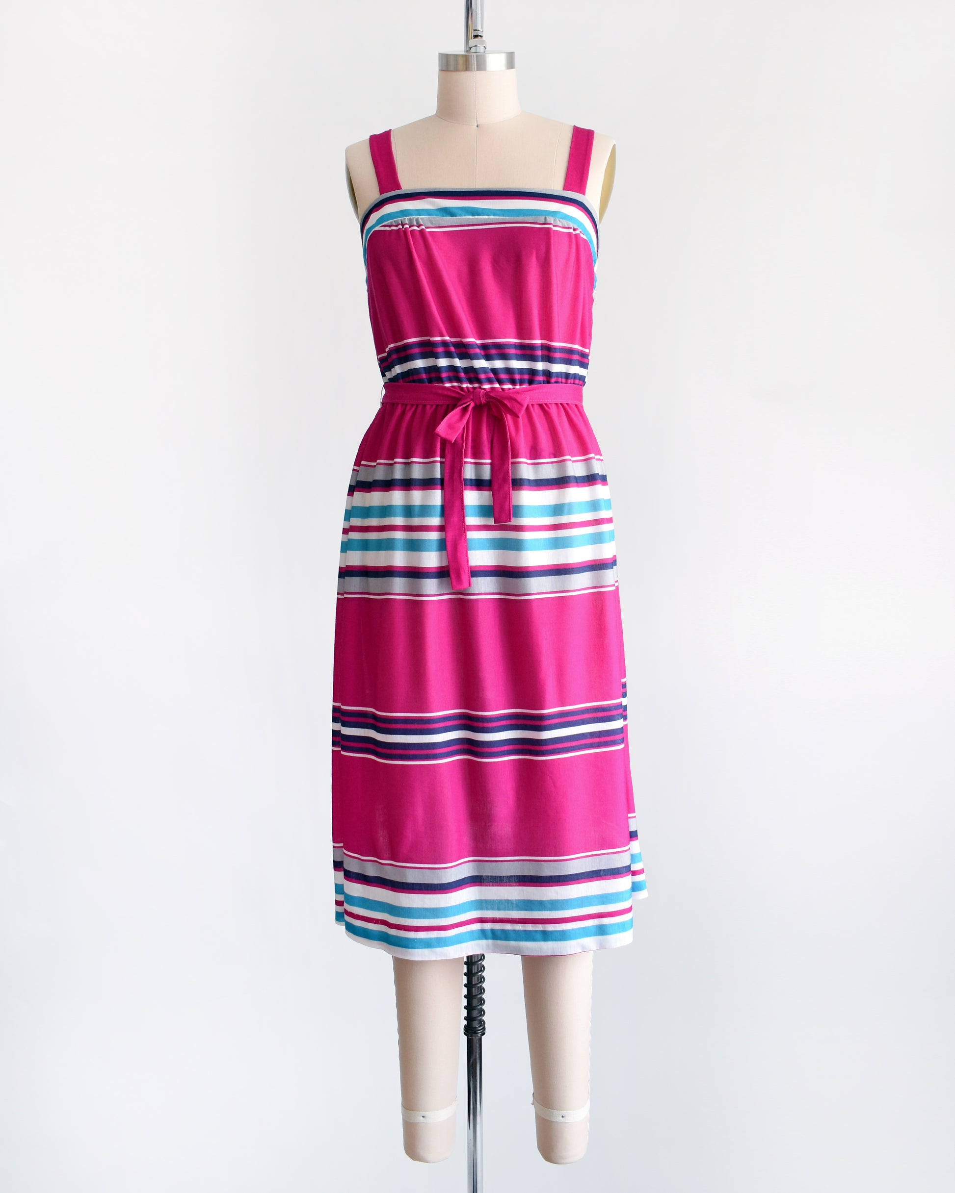 a vintage 1970s/1980s sundress that has  horizontal stripes in magenta, light blue, navy blue, gray and white, along with a matching belt.