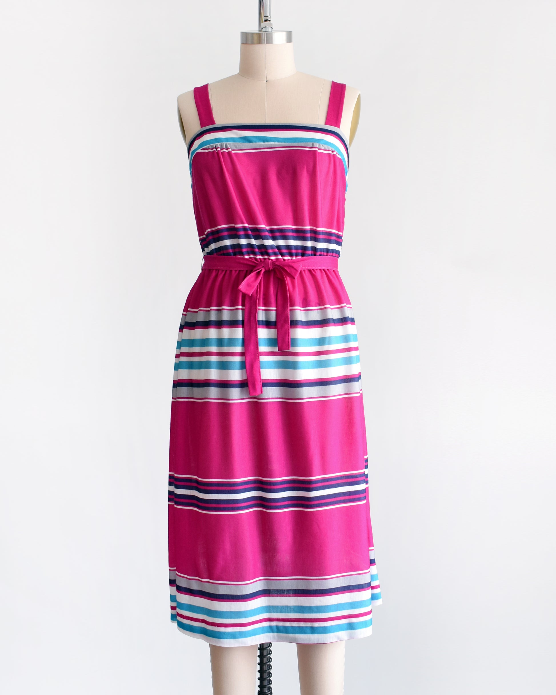 a vintage 1970s/1980s sundress that has  horizontal stripes in magenta, light blue, navy blue, gray and white, along with a matching belt.